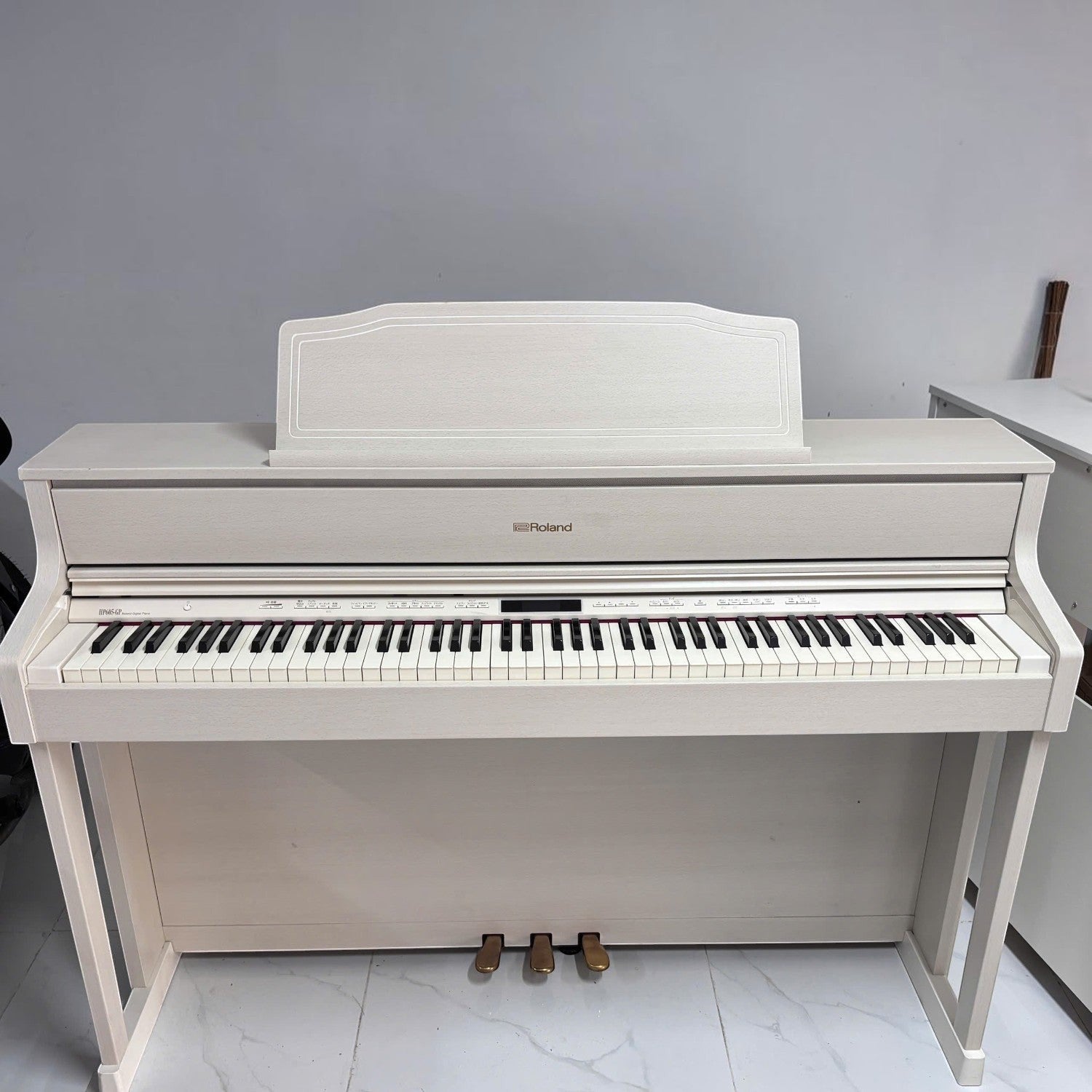 Đàn piano điện Roland HP605 màu trắng trang nhã tại Tân Nhạc Cụ, nổi bật với bàn phím gỗ lai PHA-50 cao cấp.