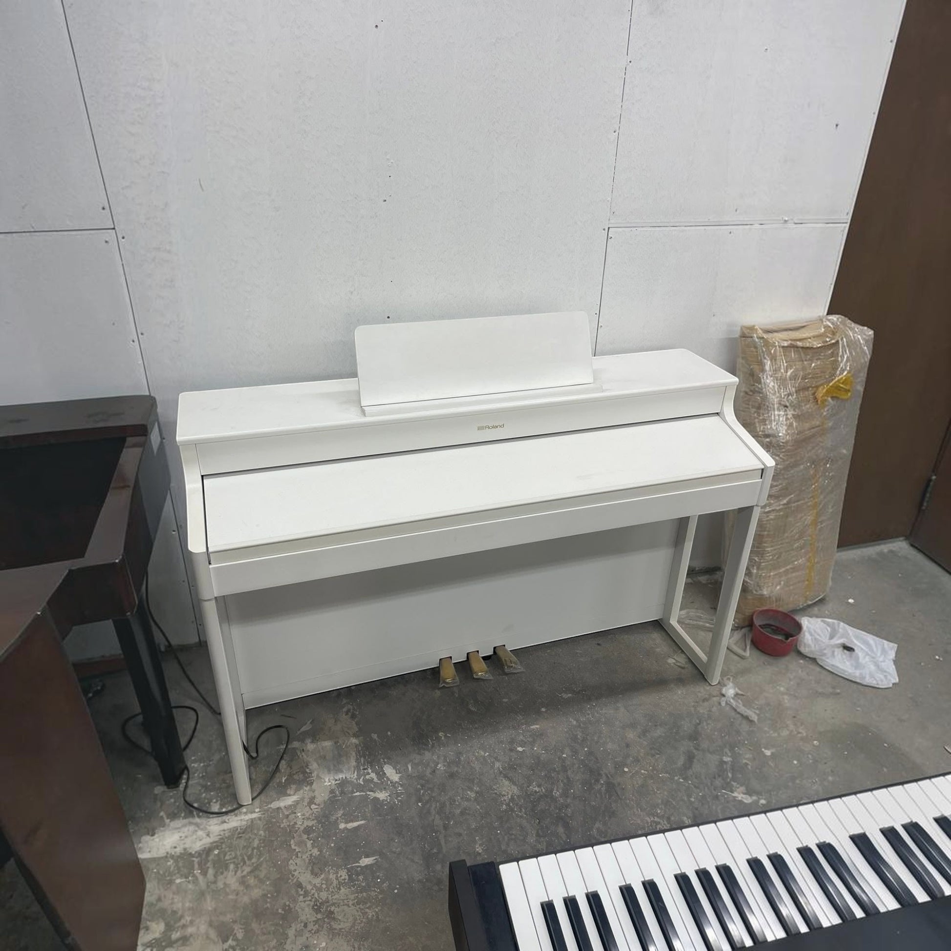 Đàn piano điện Roland HP702 màu trắng thanh lịch tại Tân Nhạc Cụ, thiết kế tủ đứng gọn gàng với 3 pedal.