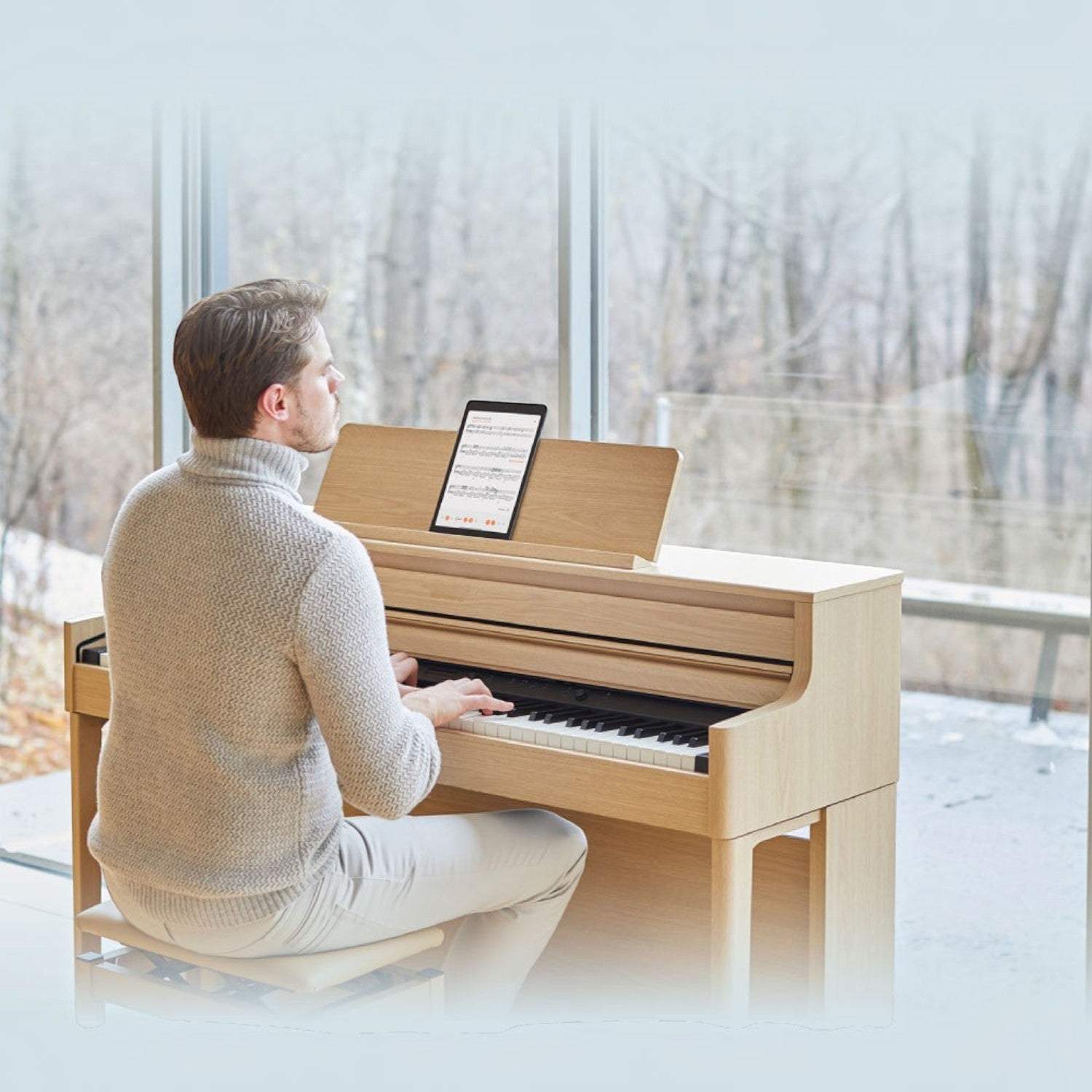 Người đàn ông chơi đàn piano điện Roland HP704 màu gỗ sáng tại TÂN NHẠC CỤ, thiết kế sang trọng bên cửa sổ lớn