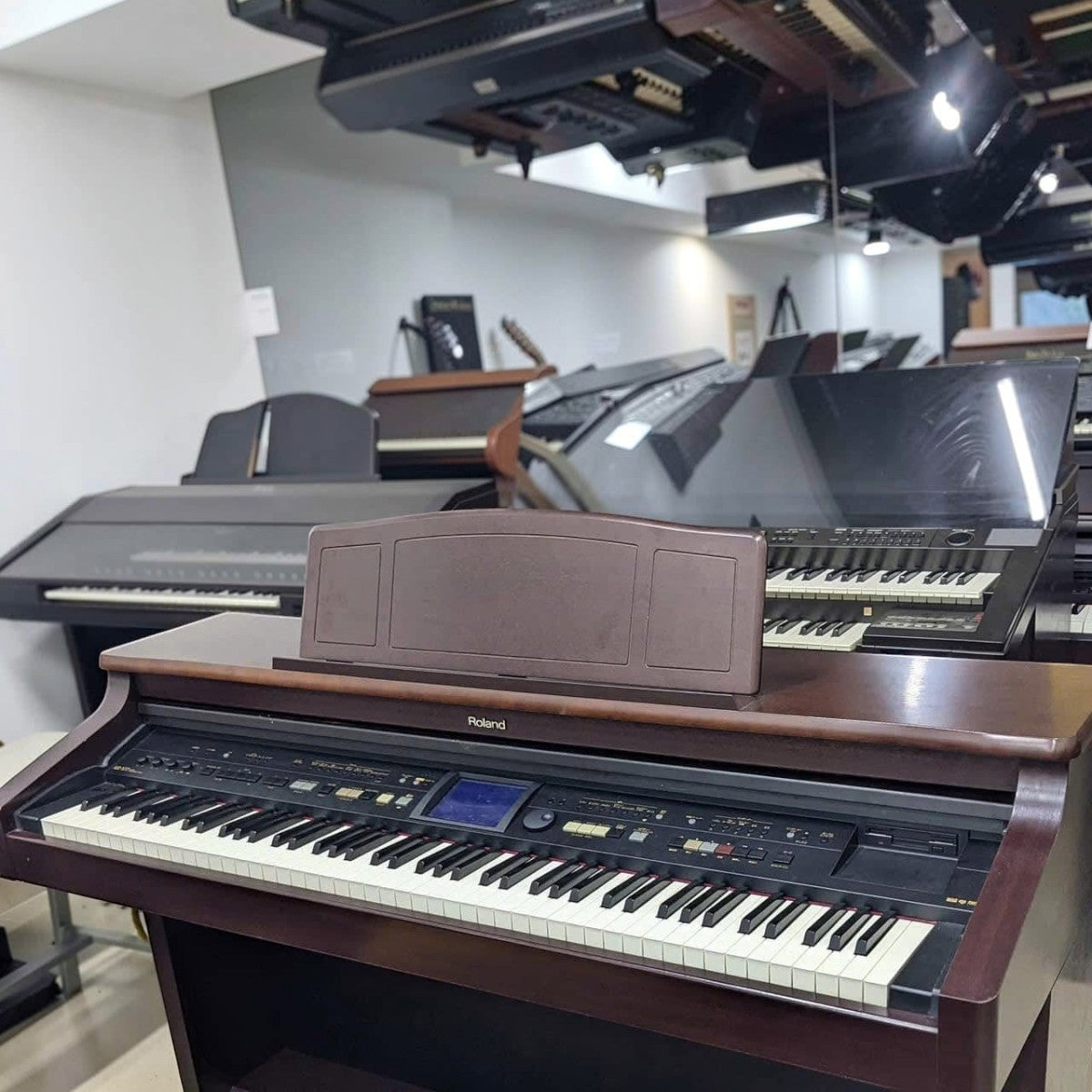 Đàn piano điện Roland KR577 màu nâu gỗ tại showroom Tân Nhạc Cụ, thiết kế dáng tủ với màn hình cảm ứng và phím búa.