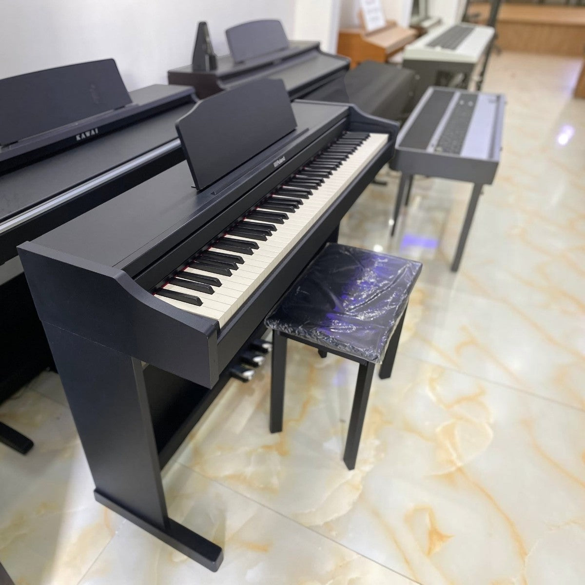 Đàn piano điện Roland RP102 màu đen tại showroom Tân Nhạc Cụ với thiết kế dáng tủ gọn gàng và ghế đàn đi kèm