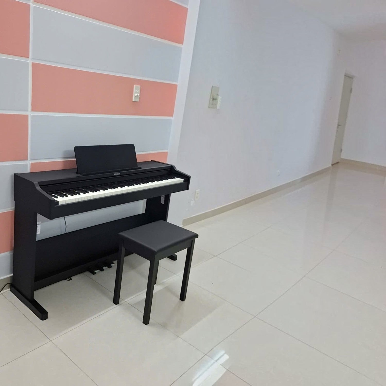 Đàn piano điện Roland RP107 màu đen dáng tủ đứng sang trọng tại không gian phòng khách của TÂN NHẠC CỤ