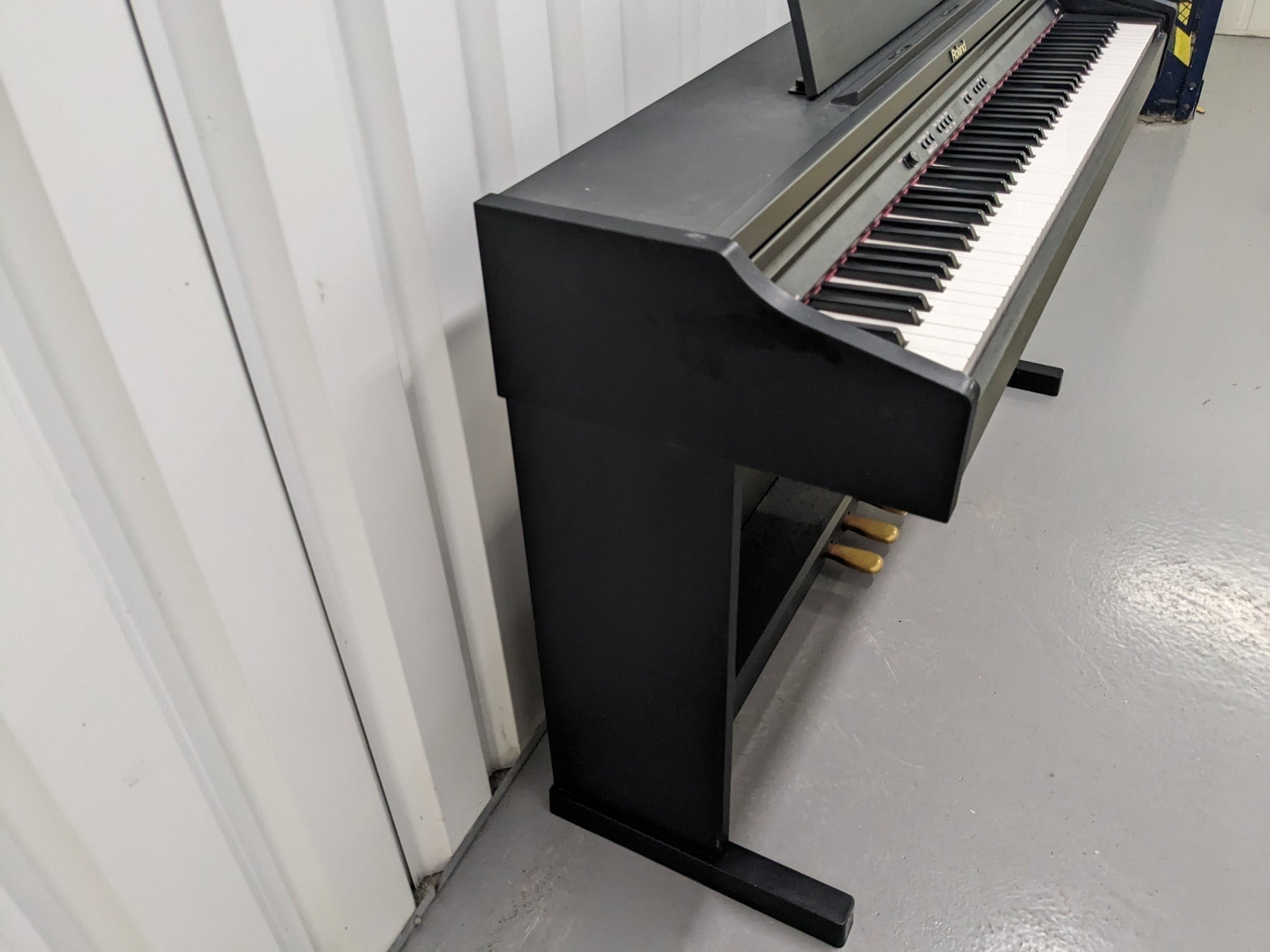 Đàn piano điện Roland RP201 màu đen dáng tủ tại TÂN NHẠC CỤ, góc nhìn nghiêng thấy rõ bàn phím 88 phím và chân đàn