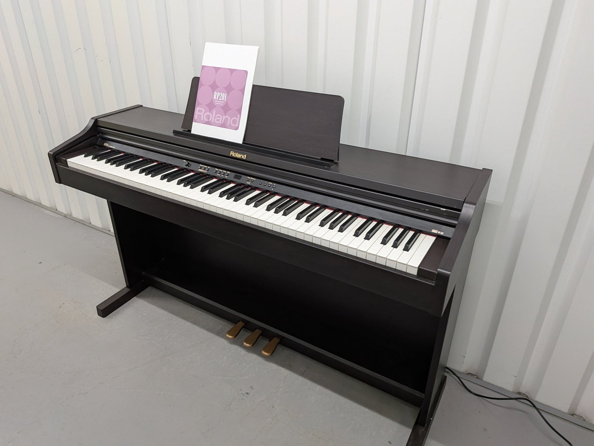 Đàn piano điện Roland RP201 màu nâu gỗ tối tại Tân Nhạc Cụ, thiết kế dáng tủ chắc chắn với 88 phím búa đàn