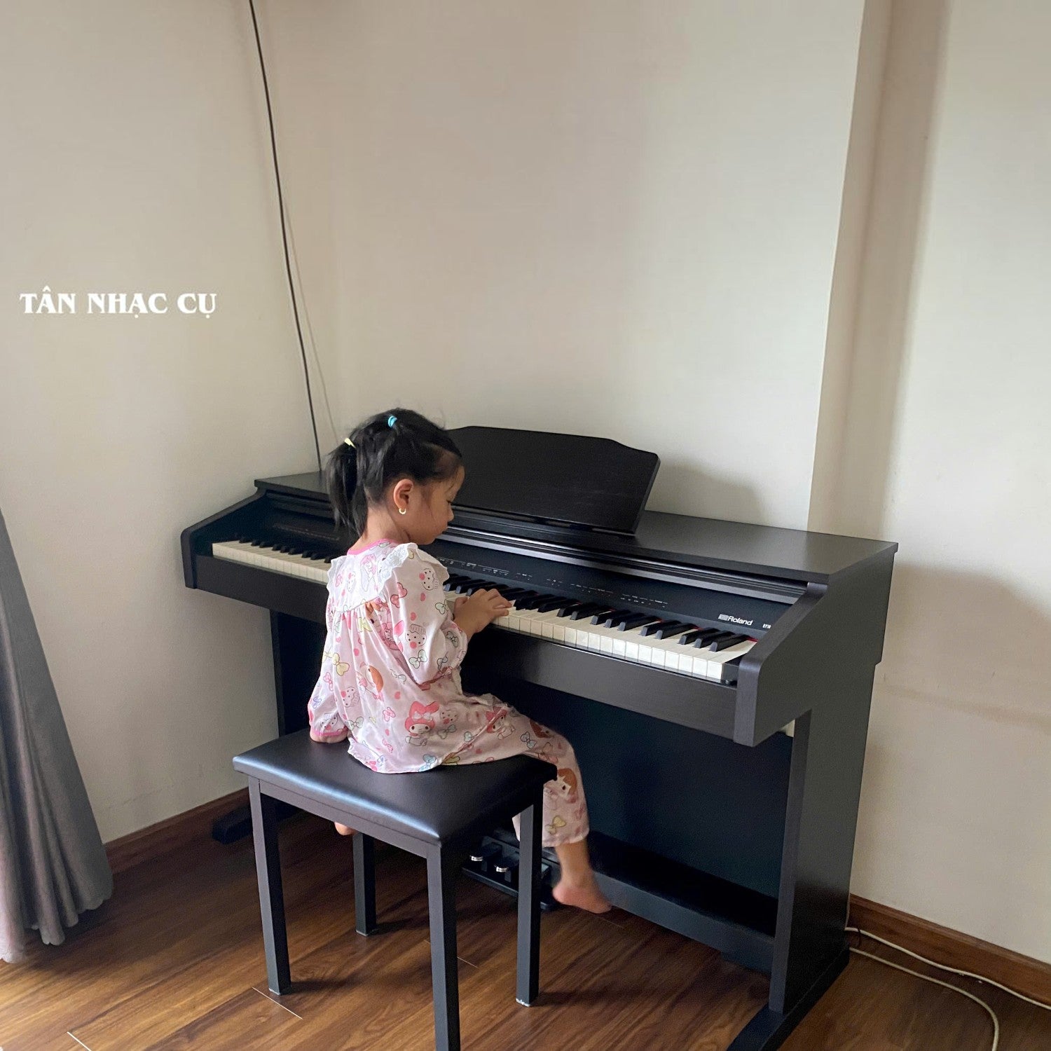 Bé gái đang tập chơi đàn piano điện Roland RP30 màu gỗ hồng sẫm tại TÂN NHẠC CỤ