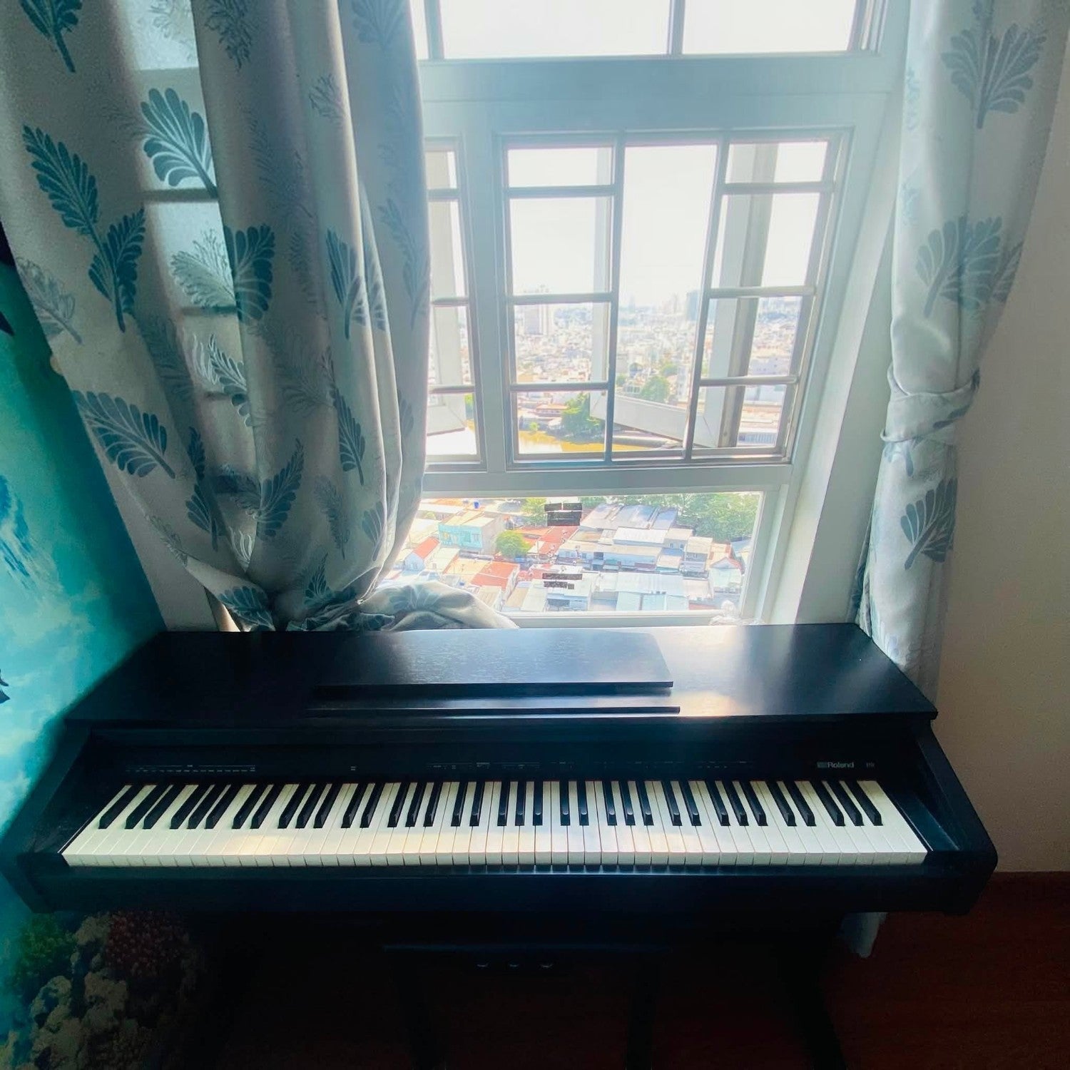 Đàn piano điện Roland RP30 màu gỗ hồng sẫm đặt cạnh cửa sổ tại showroom TÂN NHẠC CỤ
