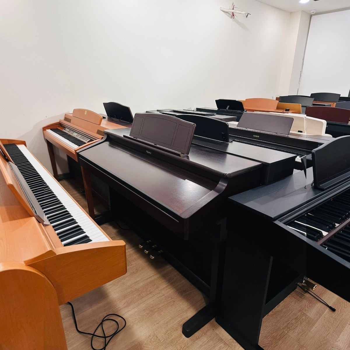 Dãy đàn piano điện Roland tại showroom TÂN NHẠC CỤ với nhiều kiểu dáng tủ gỗ và màu sắc khác nhau