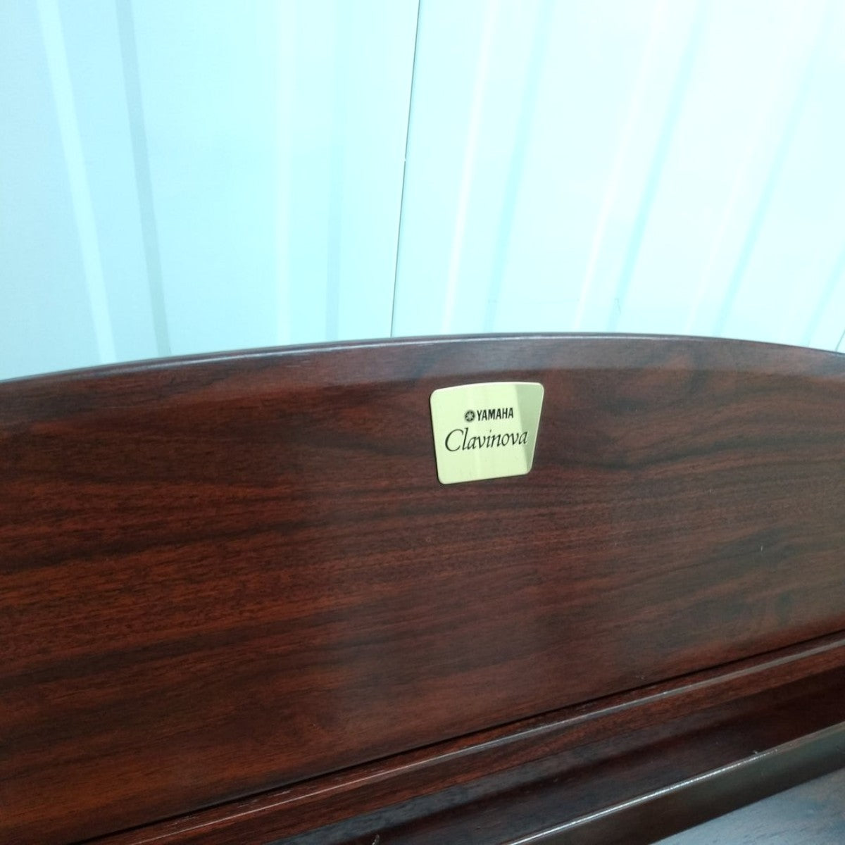 Logo Yamaha Clavinova trên đàn piano điện màu nâu gỗ sang trọng tại TÂN NHẠC CỤ