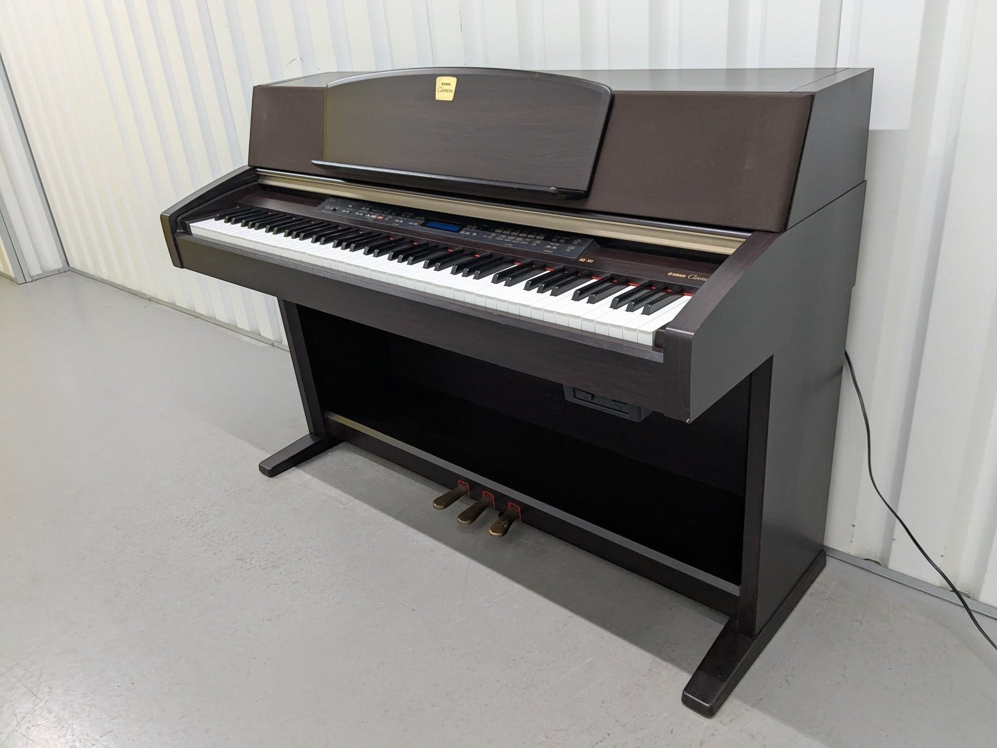 Đàn piano điện Yamaha CLP-970 màu gỗ tối sang trọng tại Tân Nhạc Cụ, thiết kế dáng tủ cổ điển với 3 pedal.