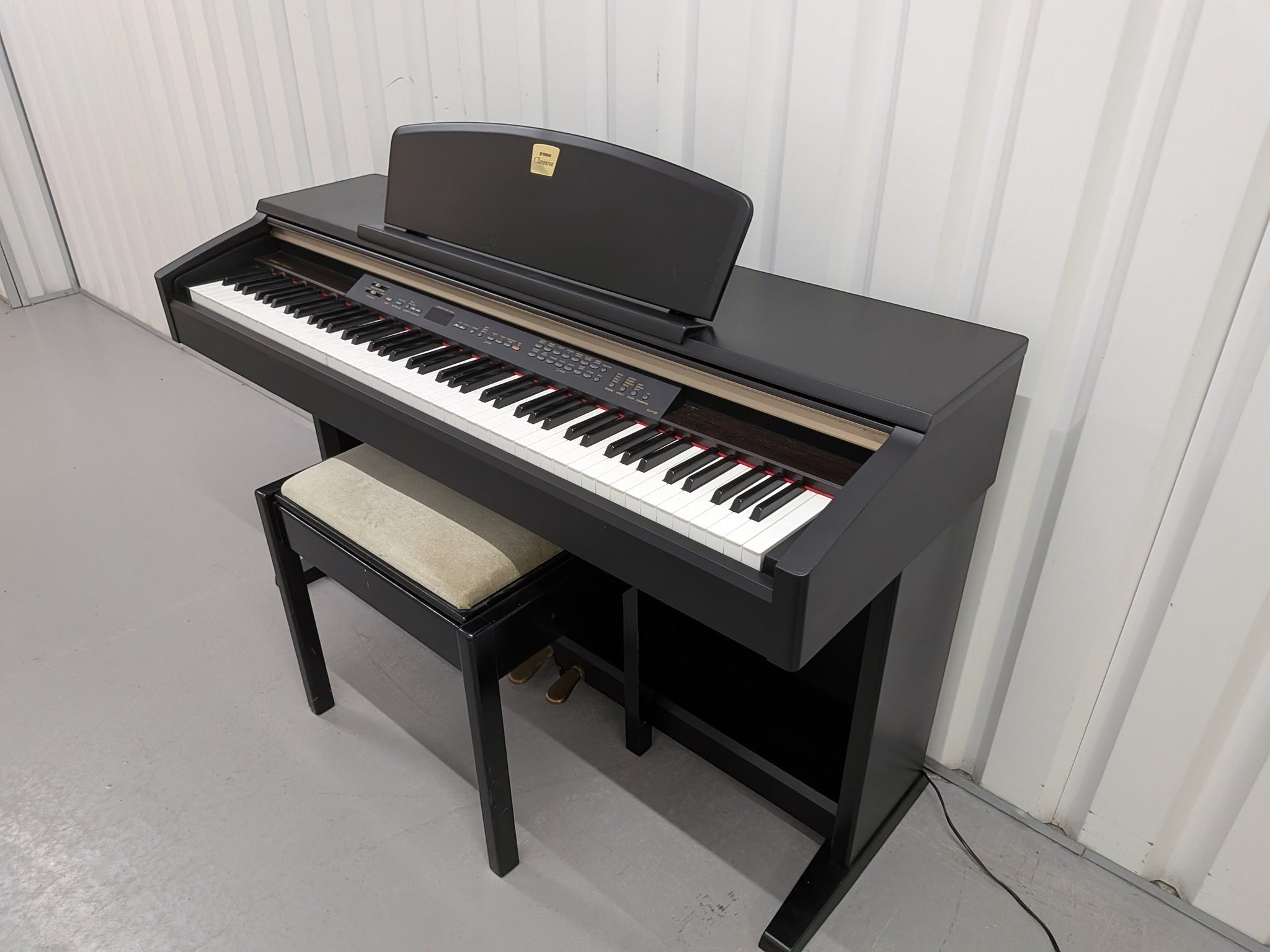 Đàn piano điện Yamaha CLP130 màu đen sang trọng tại Tân Nhạc Cụ, thiết kế thùng đứng cổ điển với ghế ngồi đi kèm.
