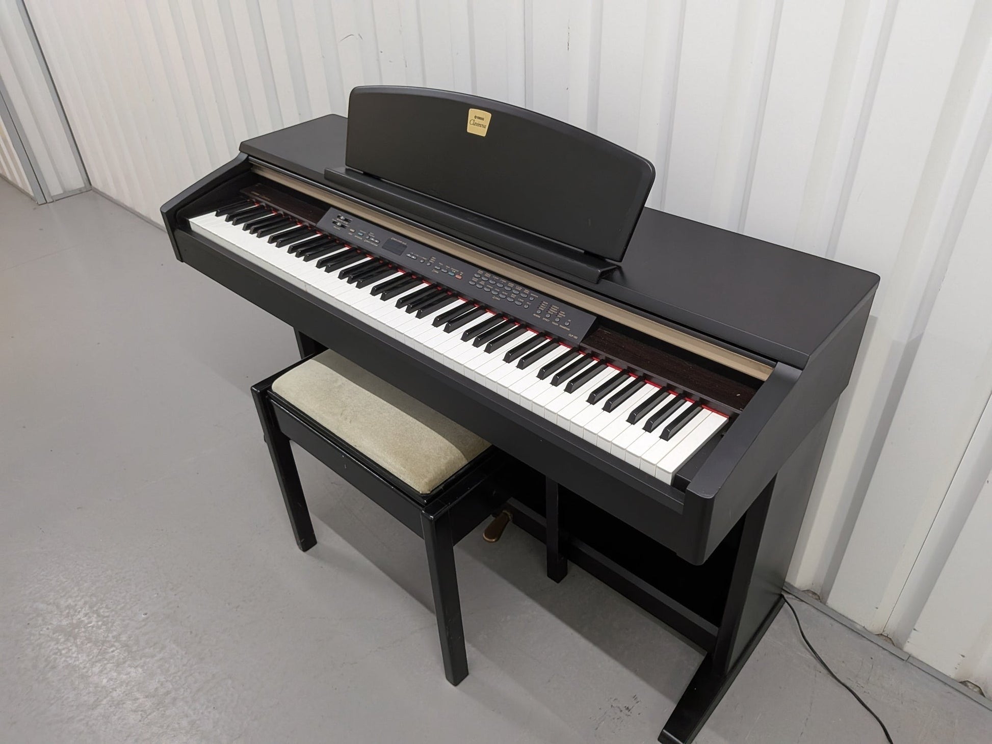 Đàn piano điện TÂN NHẠC CỤ Yamaha CLP130 màu đen với bàn phím nặng GH, thiết kế thùng đứng cổ điển và ghế đi kèm