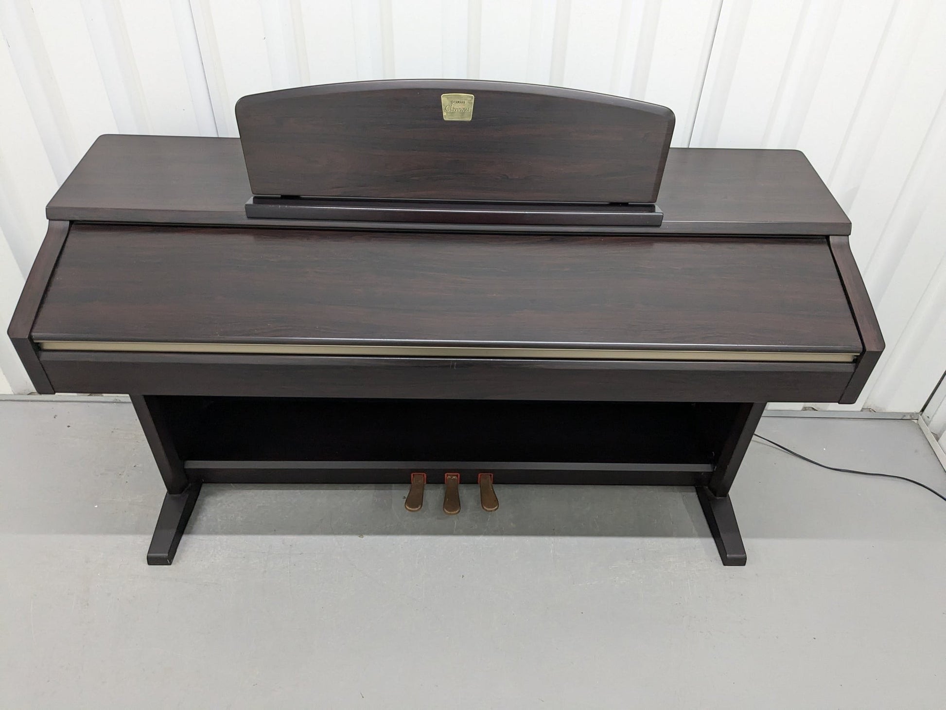 Đàn piano điện TÂN NHẠC CỤ Yamaha CLP130 màu gỗ hồng đậm với thiết kế thùng đứng cổ điển và 3 pedal chắc chắn