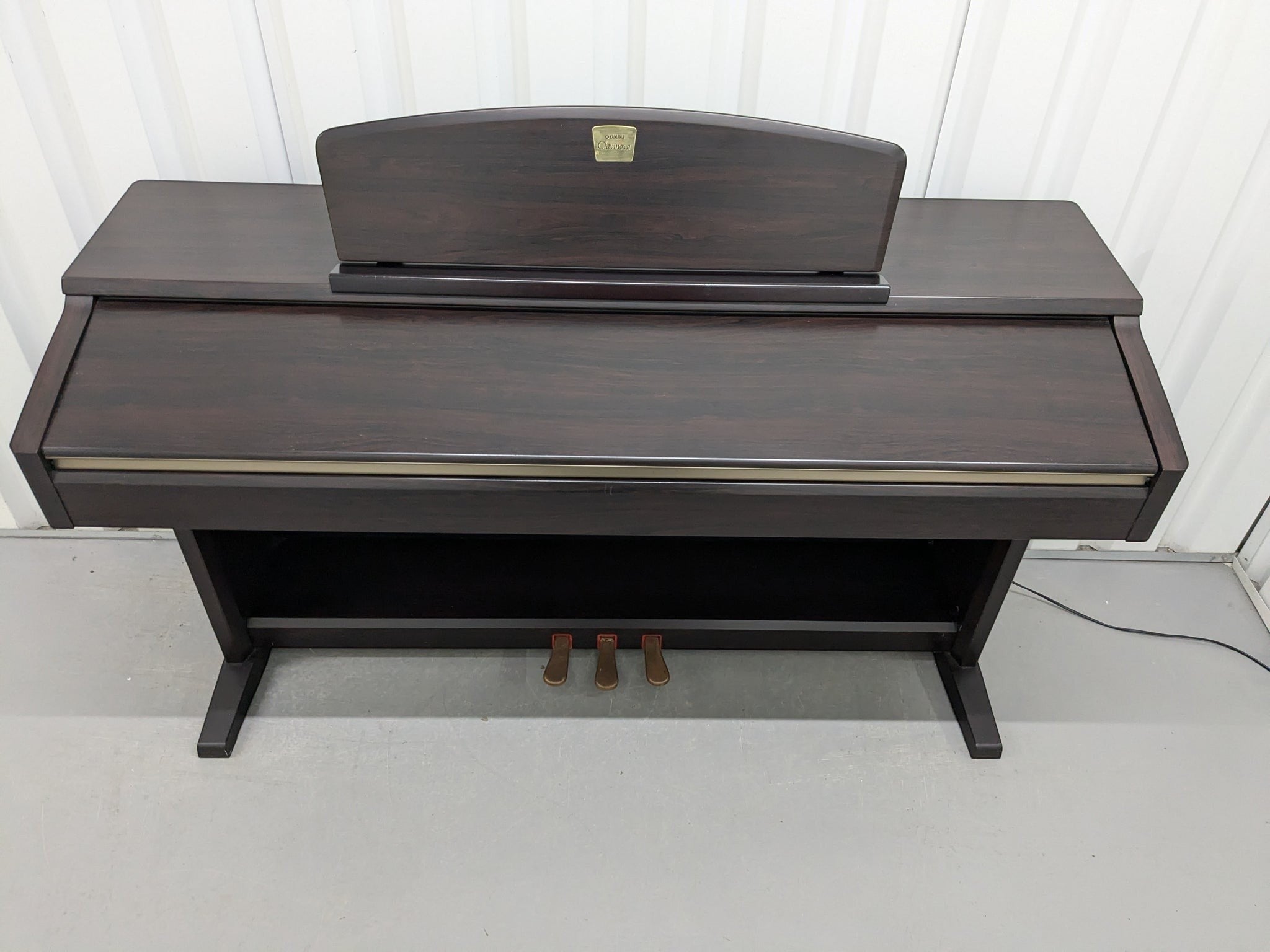 Đàn piano điện TÂN NHẠC CỤ Yamaha CLP130 màu gỗ hồng đậm với thiết kế thùng đứng cổ điển và 3 pedal chắc chắn