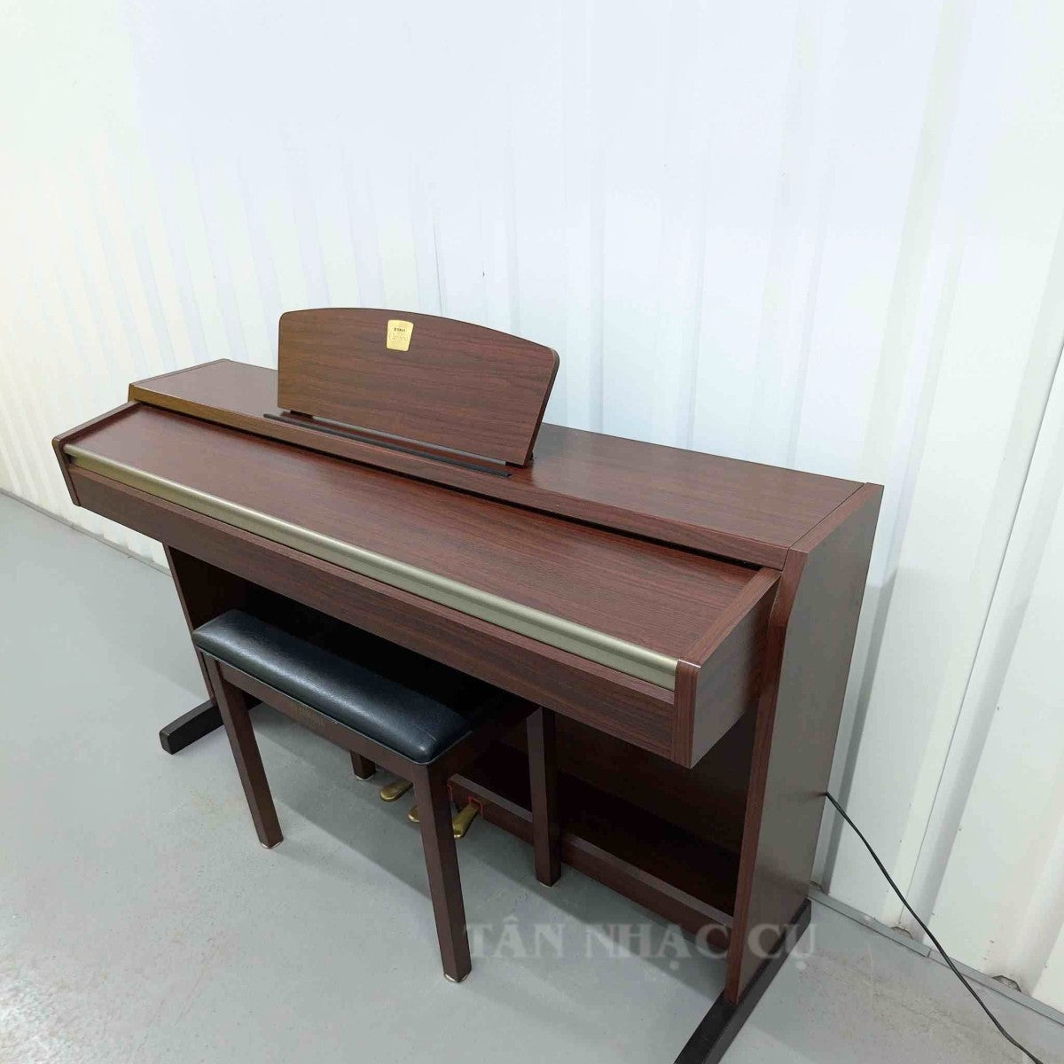 Đàn piano điện Yamaha CLP220 dáng tủ màu gỗ sang trọng tại TÂN NHẠC CỤ, thiết kế upright cổ điển với ghế đi kèm.