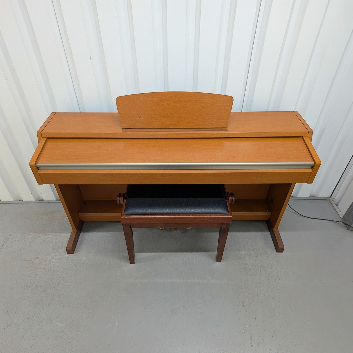 Đàn piano điện TÂN NHẠC CỤ Yamaha CLP220 dáng tủ màu gỗ tự nhiên với ghế đàn đi kèm, thiết kế thanh lịch.