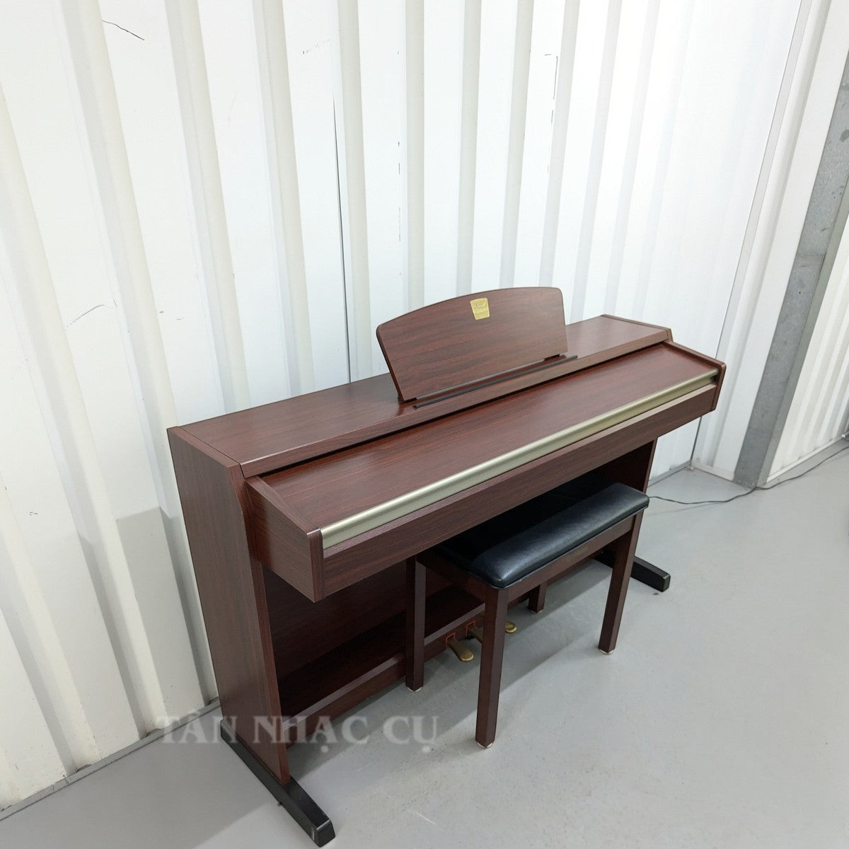 Đàn piano điện Yamaha CLP220 dáng tủ màu gỗ nâu thanh lịch tại TÂN NHẠC CỤ, kèm ghế ngồi chắc chắn.