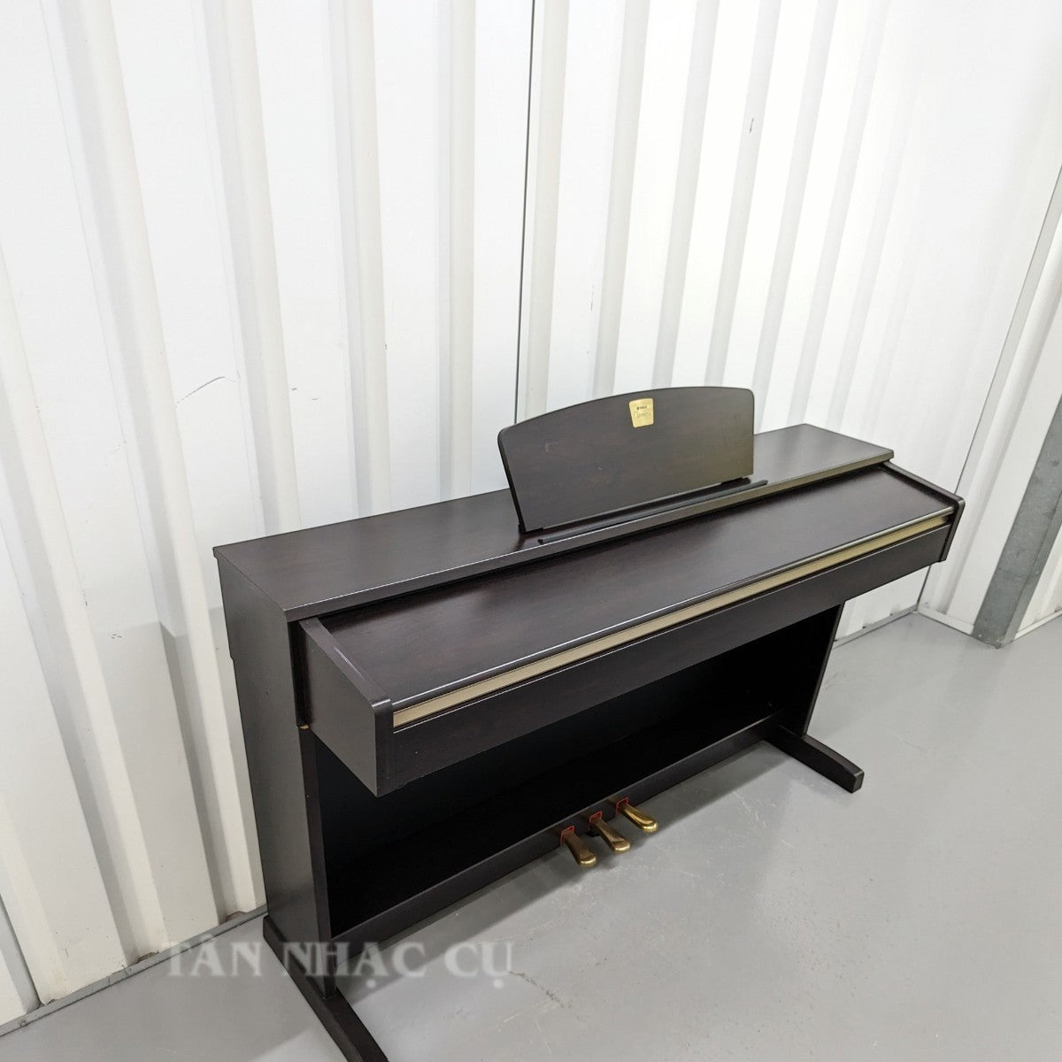Đàn piano điện Yamaha CLP-320 màu nâu gỗ sang trọng, dáng tủ đứng tại cửa hàng TÂN NHẠC CỤ