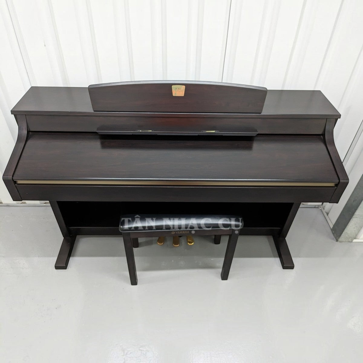 Đàn piano điện TÂN NHẠC CỤ Yamaha CLP340 màu gỗ tối sang trọng, thiết kế thùng đứng chắc chắn với ghế đàn đi kèm.
