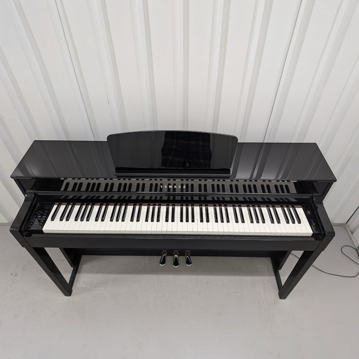 Đàn piano điện TÂN NHẠC CỤ Yamaha CLP535 màu đen bóng, thiết kế sang trọng với 88 phím GH3X và ba pedal kim loại.