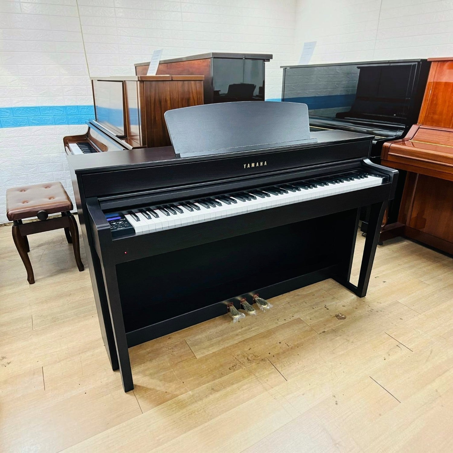 Đàn piano điện Yamaha CLP-645 màu đen tại showroom TÂN NHẠC CỤ với thiết kế dáng tủ sang trọng và bàn phím gỗ NWX