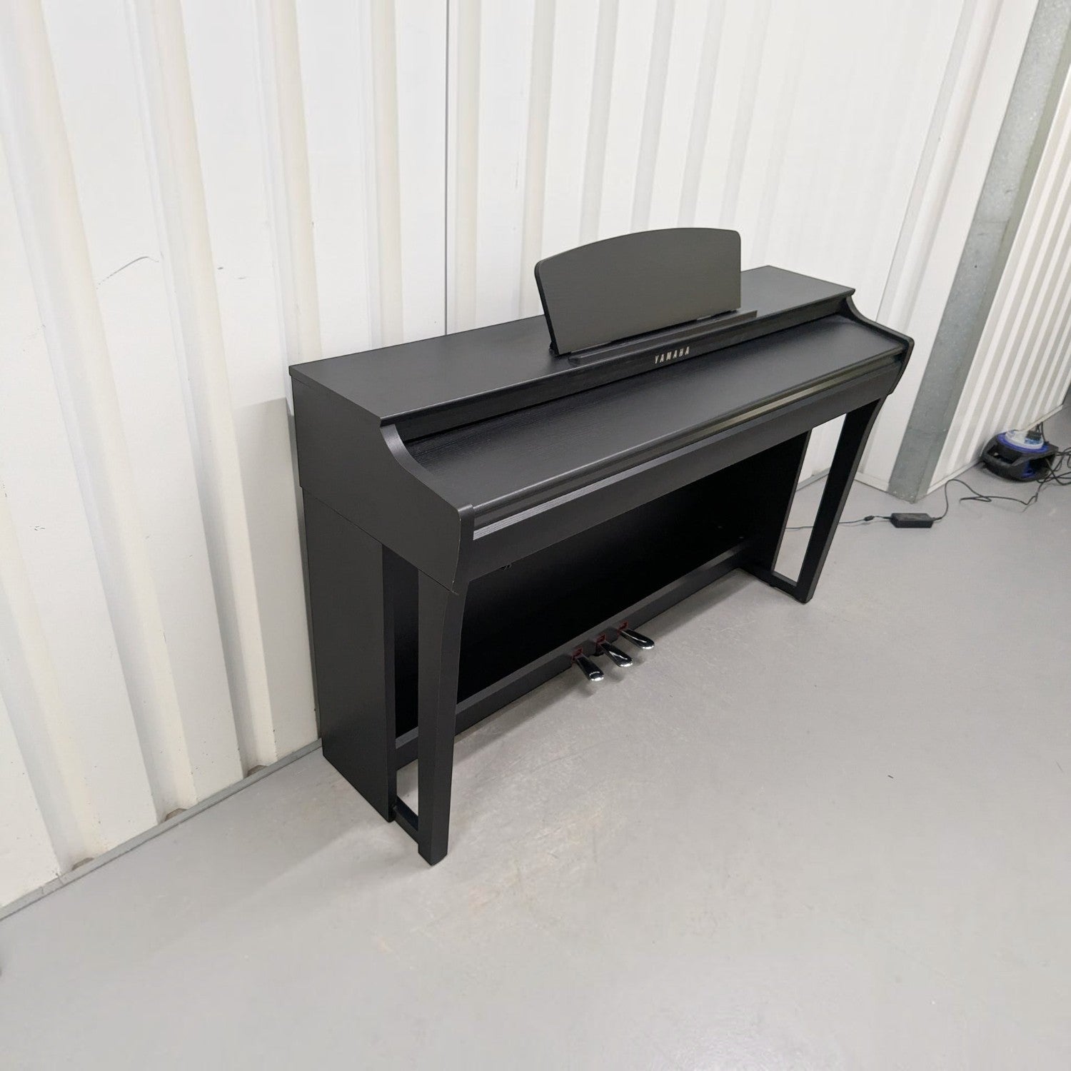 Đàn piano điện Yamaha CLP725 màu đen sang trọng tại Tân Nhạc Cụ, thiết kế dáng tủ hiện đại với 3 pedal.