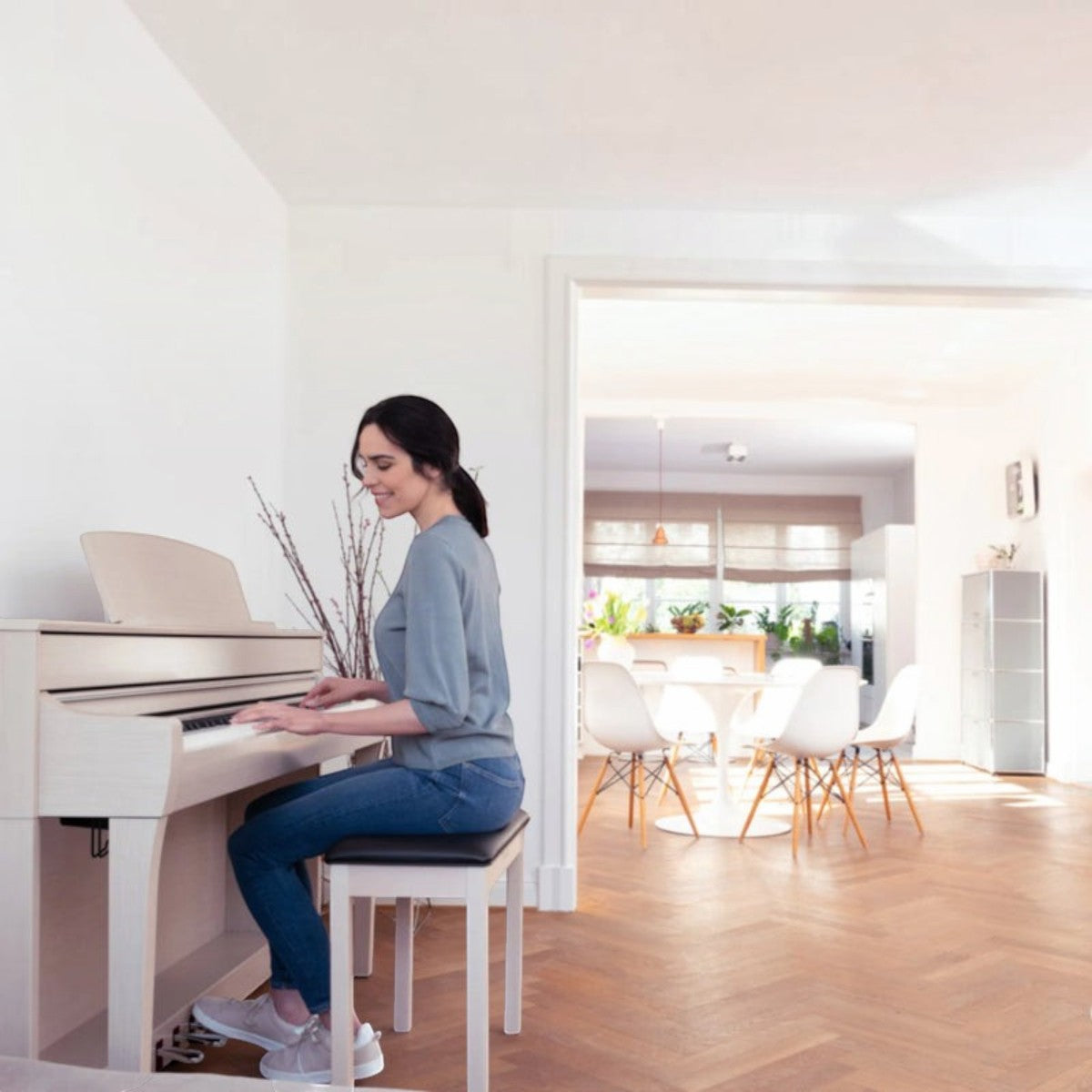 Người phụ nữ chơi đàn piano điện Yamaha CLP-735 màu trắng trang nhã tại Tân Nhạc Cụ trong không gian phòng khách sáng