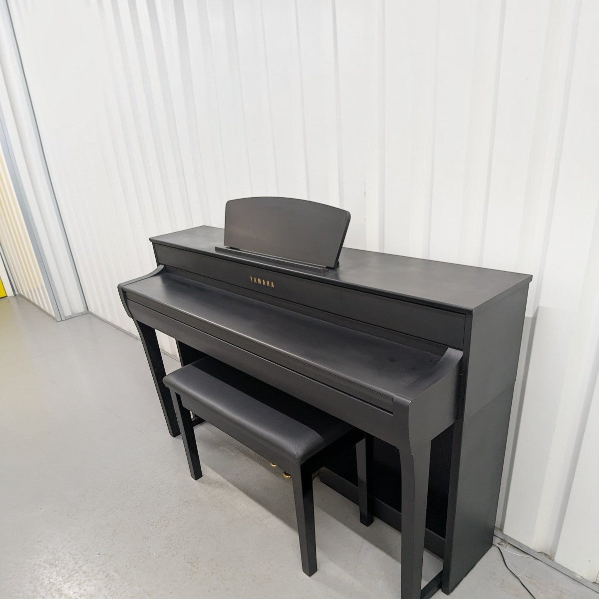 Đàn piano điện Yamaha CLP-735 màu đen sang trọng tại TÂN NHẠC CỤ, thiết kế dáng tủ đứng kèm ghế ngồi đồng bộ.