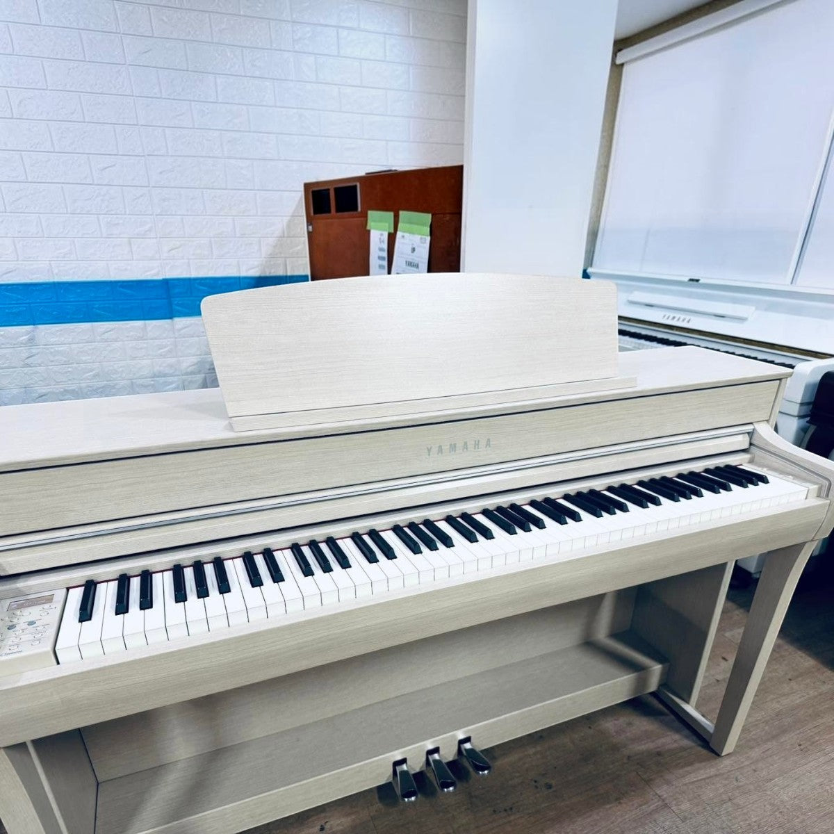 Đàn piano điện Yamaha CLP-745 màu trắng vân gỗ tại Tân Nhạc Cụ, thiết kế sang trọng với bàn phím gỗ GrandTouch-S.
