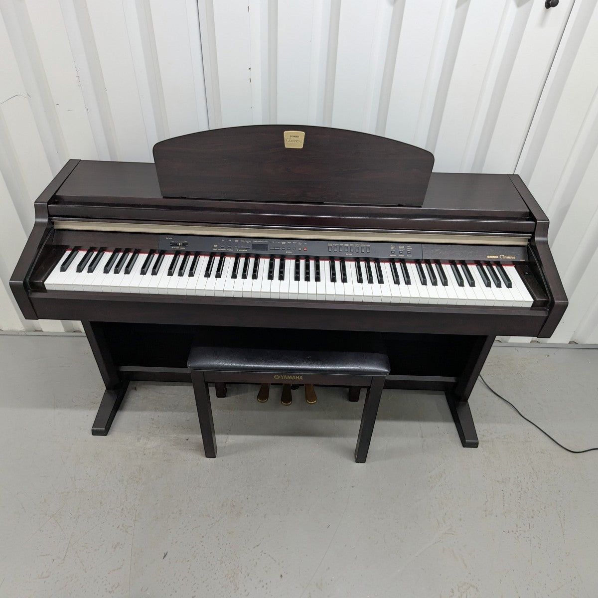 Đàn piano điện Yamaha CLP930 dáng tủ màu gỗ nâu sang trọng tại TÂN NHẠC CỤ, kèm ghế ngồi đồng bộ.