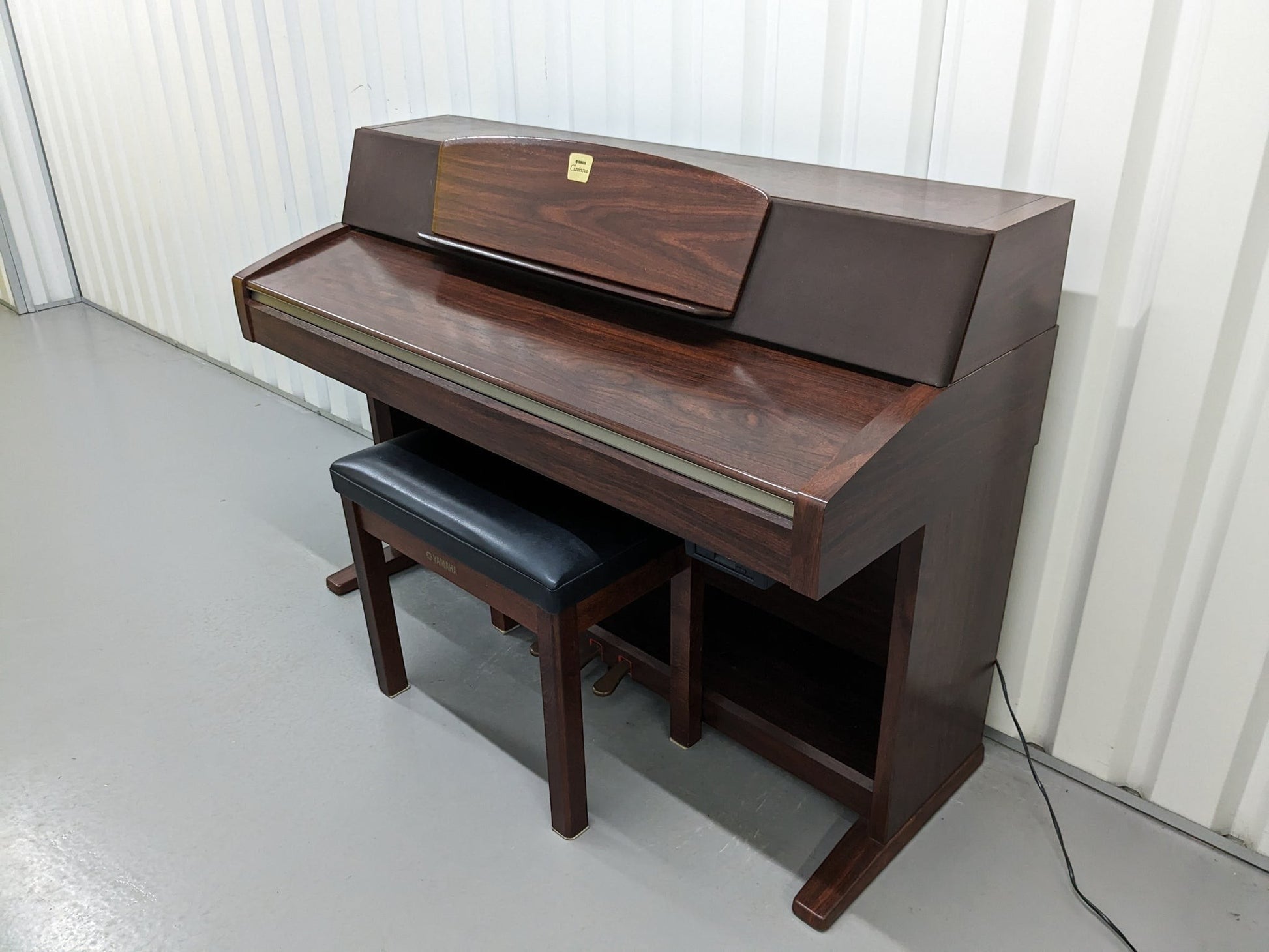 Đàn piano điện Yamaha CLP970 màu gỗ nâu sang trọng tại TÂN NHẠC CỤ, thiết kế dáng tủ cổ điển với ghế ngồi đi kèm.