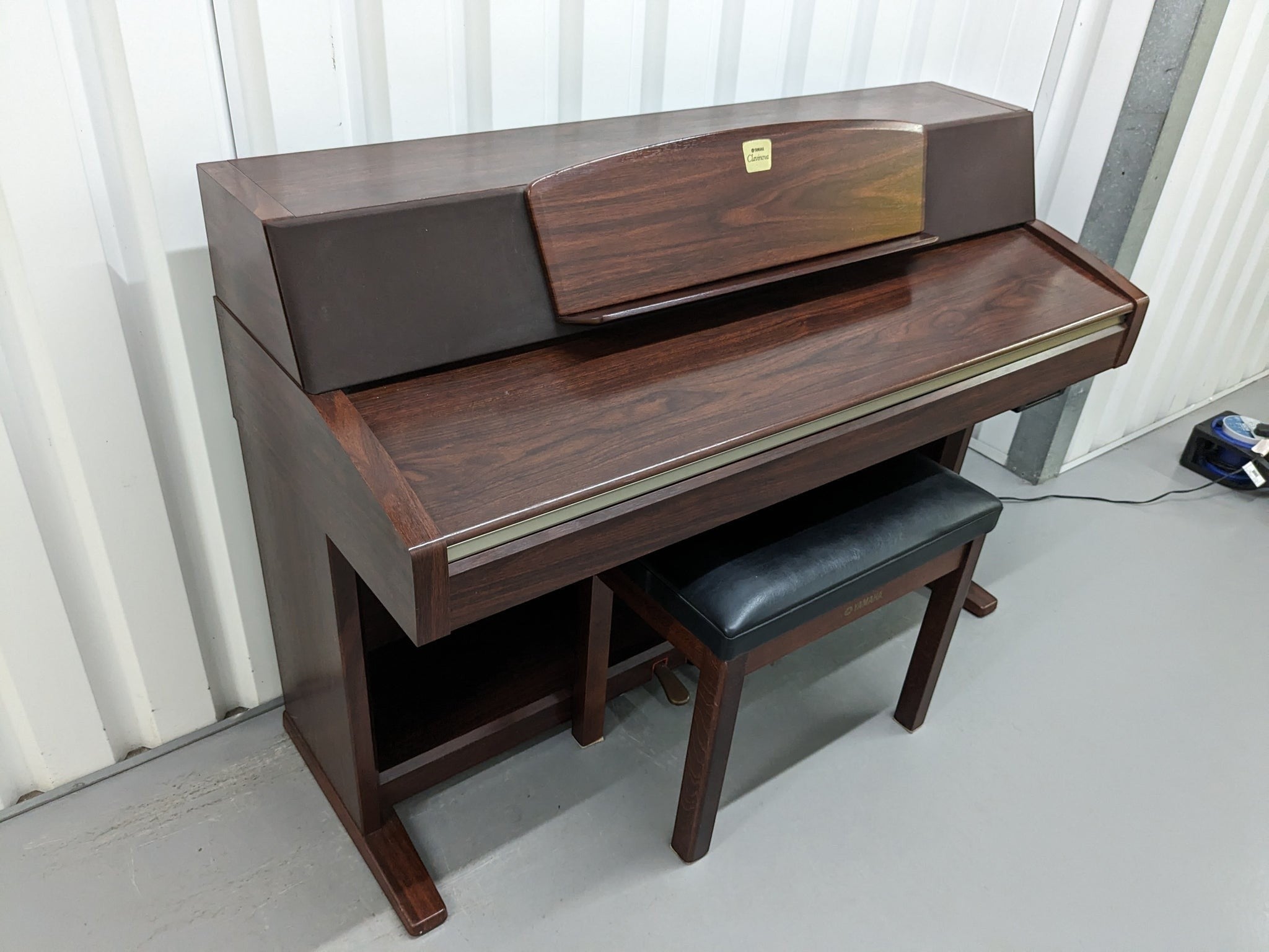 Đàn piano điện Yamaha CLP-970 màu gỗ sang trọng tại Tân Nhạc Cụ với thiết kế dáng tủ cổ điển và ghế ngồi đi kèm