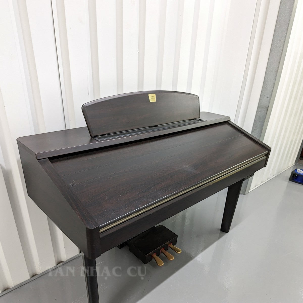 Đàn piano điện Yamaha CVP207 màu gỗ tối sang trọng tại TÂN NHẠC CỤ, thiết kế dáng tủ cổ điển với 3 pedal.
