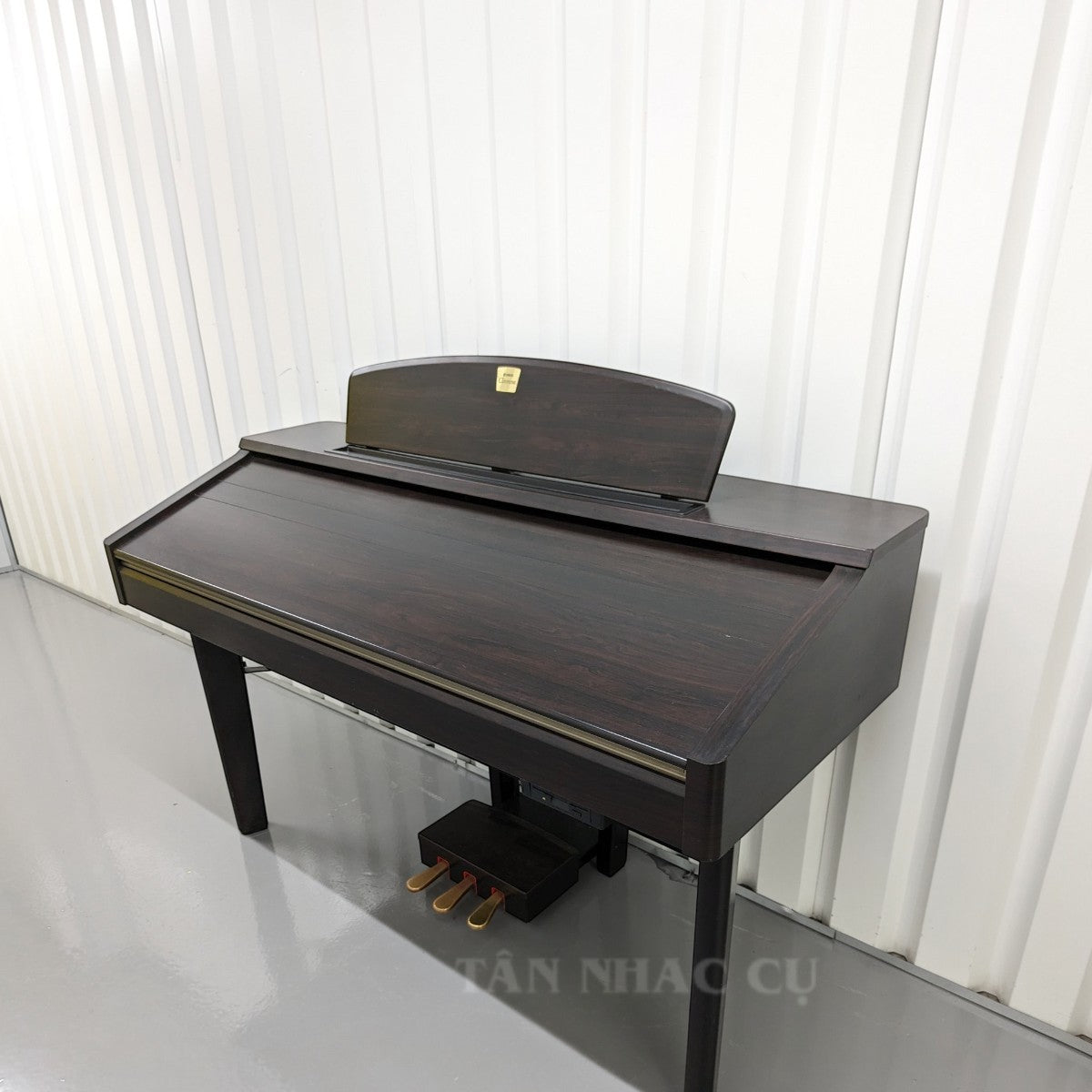 Đàn piano điện Yamaha CVP-207 màu gỗ tối sang trọng tại Tân Nhạc Cụ, thiết kế dáng tủ cổ điển với 3 pedal.