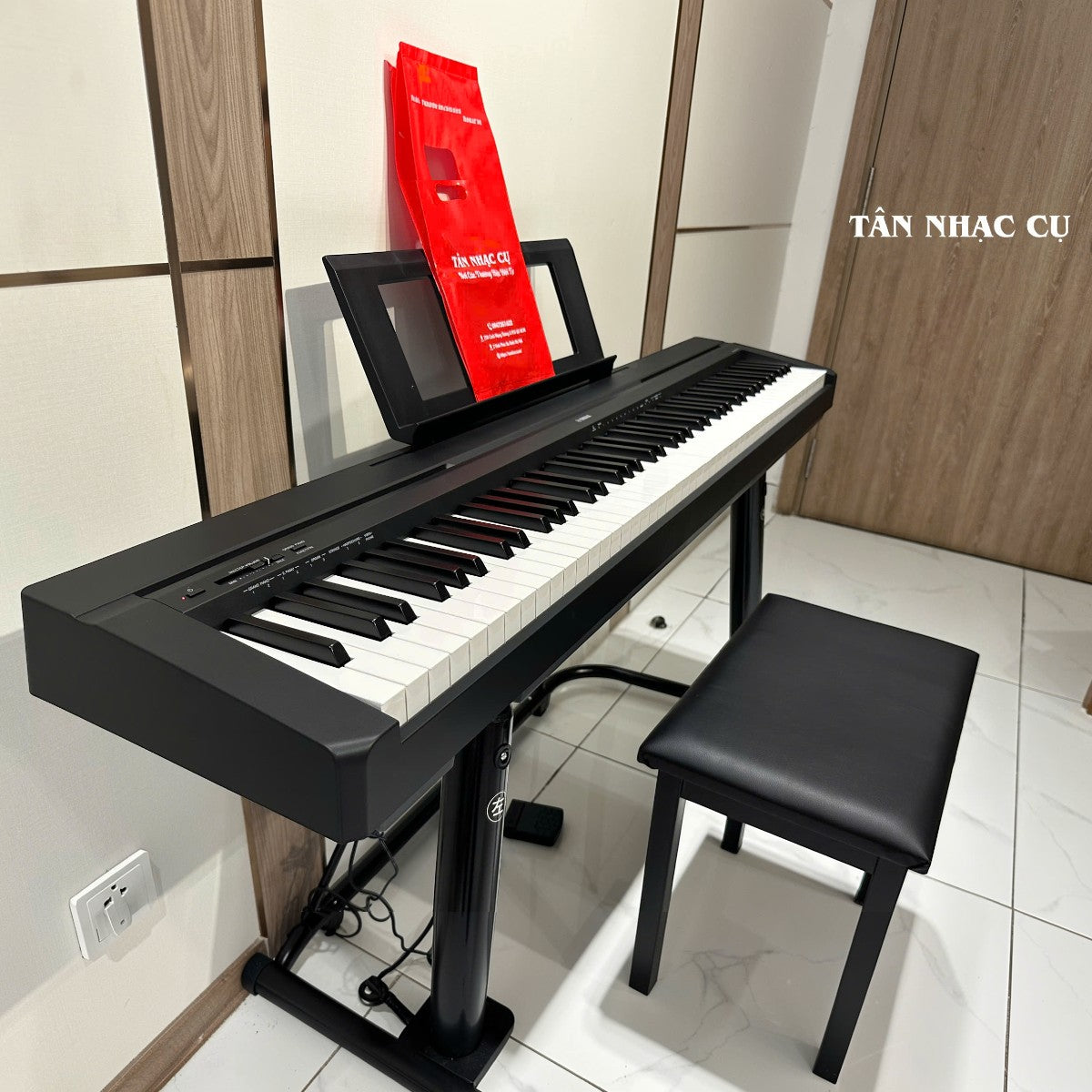 Đàn piano điện Yamaha P-45 màu đen tại TÂN NHẠC CỤ với 88 phím búa, giá nhạc và ghế ngồi trong không gian hiện đại