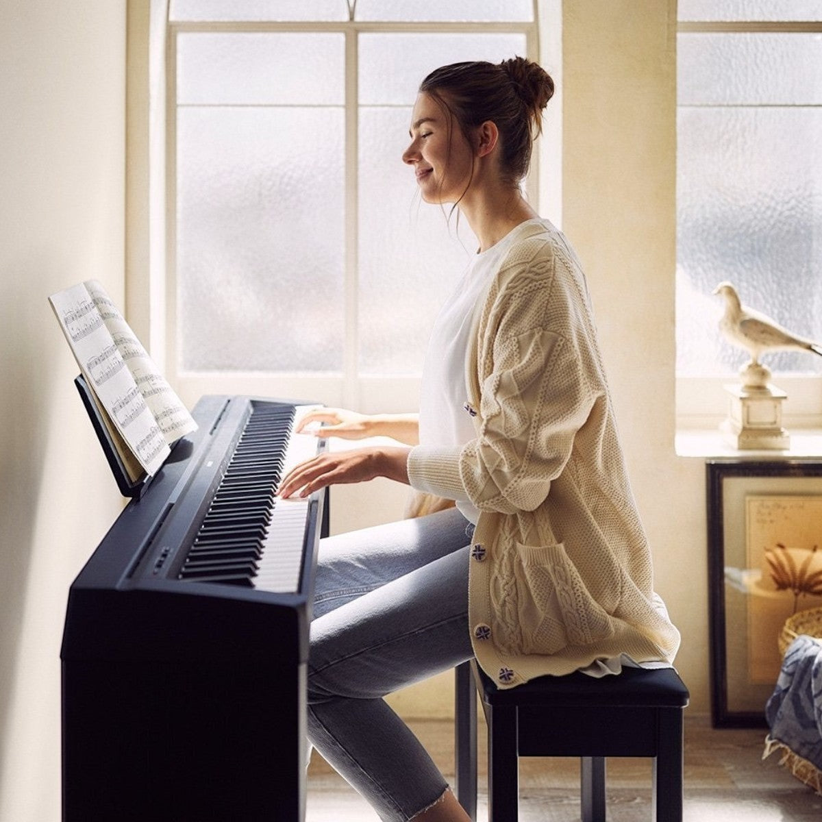 Cô gái đang chơi đàn piano điện Yamaha P-45 màu đen tại Tân Nhạc Cụ, thiết kế 88 phím búa GHS nhỏ gọn và tinh tế