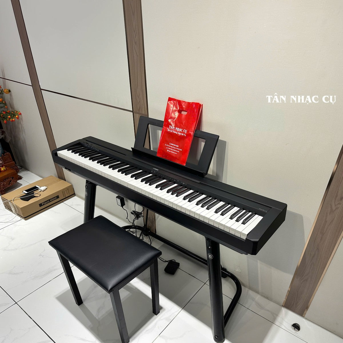 Đàn piano điện TÂN NHẠC CỤ Yamaha P-45 màu đen với 88 phím búa GHS, kèm ghế và chân đàn trong không gian phòng.