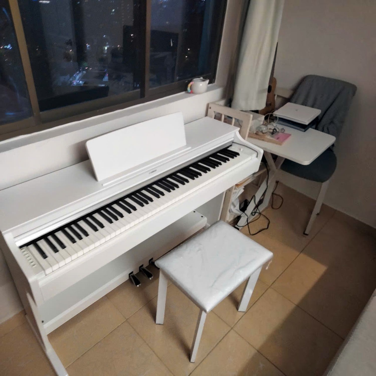 Đàn piano điện Yamaha YDP-163 màu trắng dáng tủ tại Tân Nhạc Cụ, kèm ghế ngồi cùng tông màu trong không gian phòng.