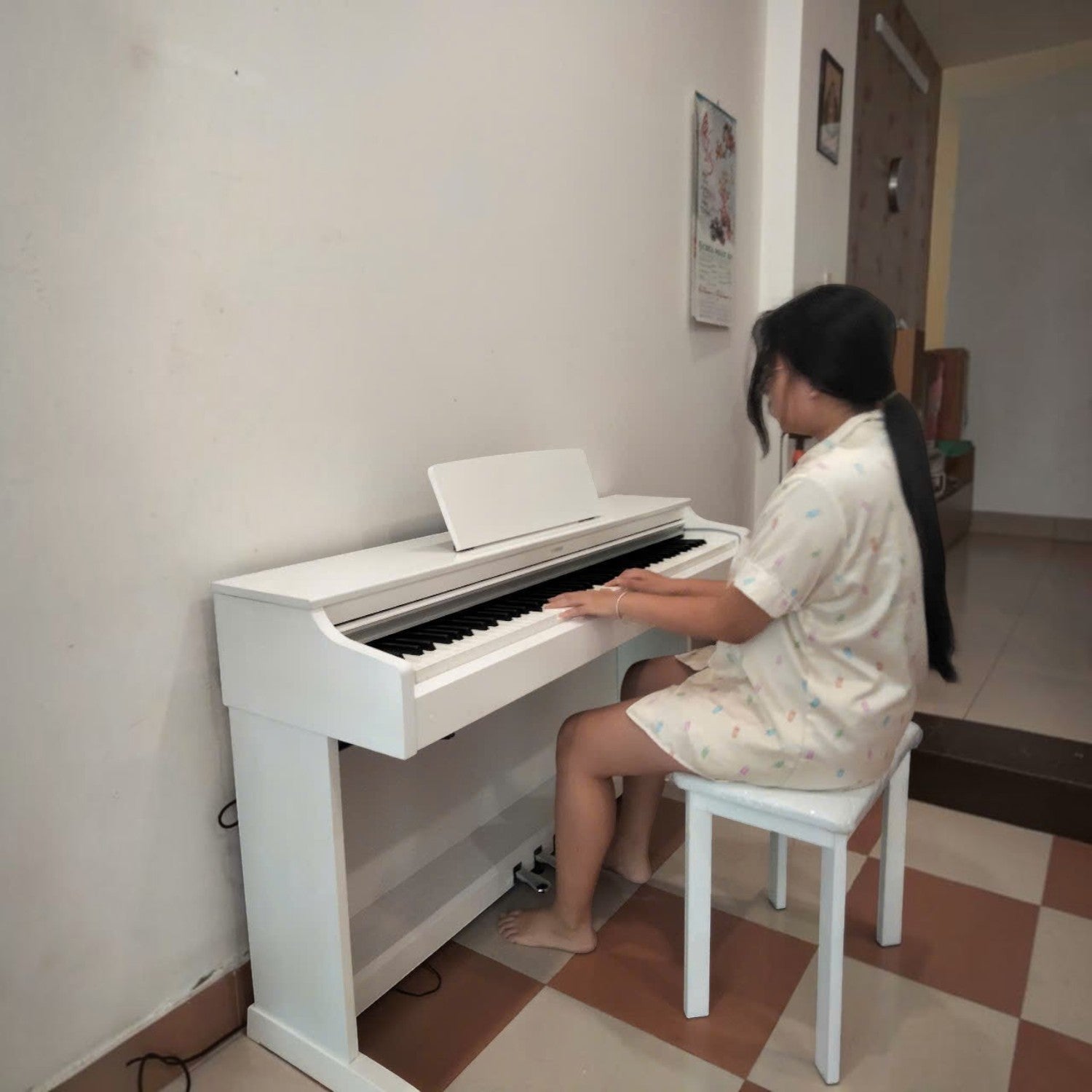 Cô gái đang chơi đàn piano điện Yamaha YDP-163 màu trắng tại Tân Nhạc Cụ, thiết kế dáng tủ sang trọng.
