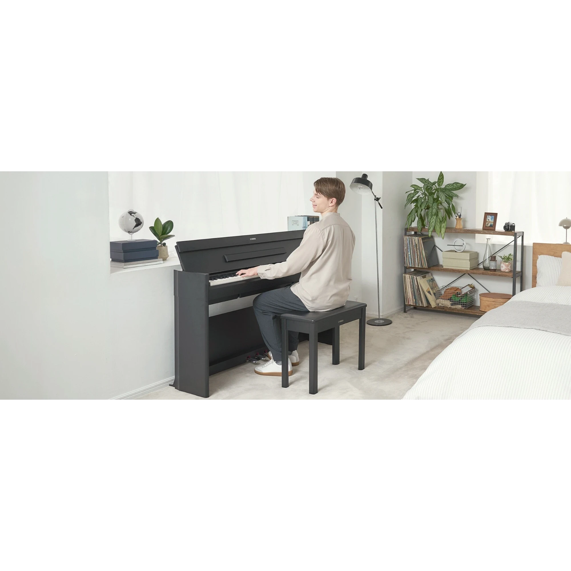 Người đàn ông chơi đàn piano điện Yamaha YDP-S56 dáng slim màu đen trong phòng ngủ hiện đại tại Tân Nhạc Cụ