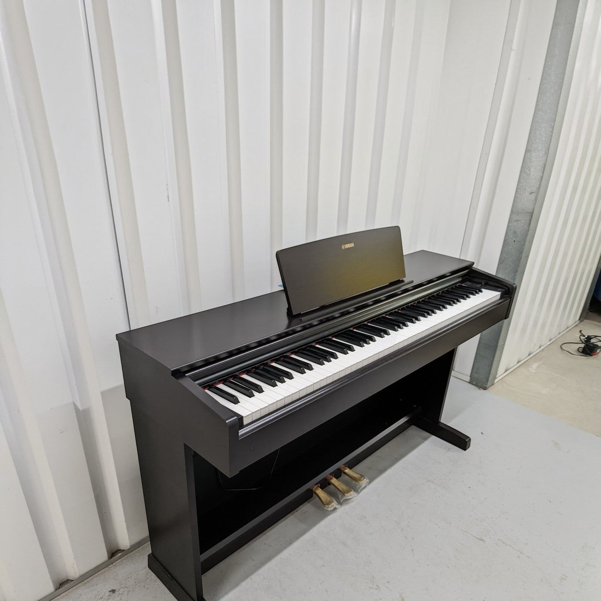 Đàn piano điện Yamaha YDP-103 màu đen dáng tủ tại TÂN NHẠC CỤ, thiết kế gọn gàng với 88 phím búa GHS và 3 pedal.