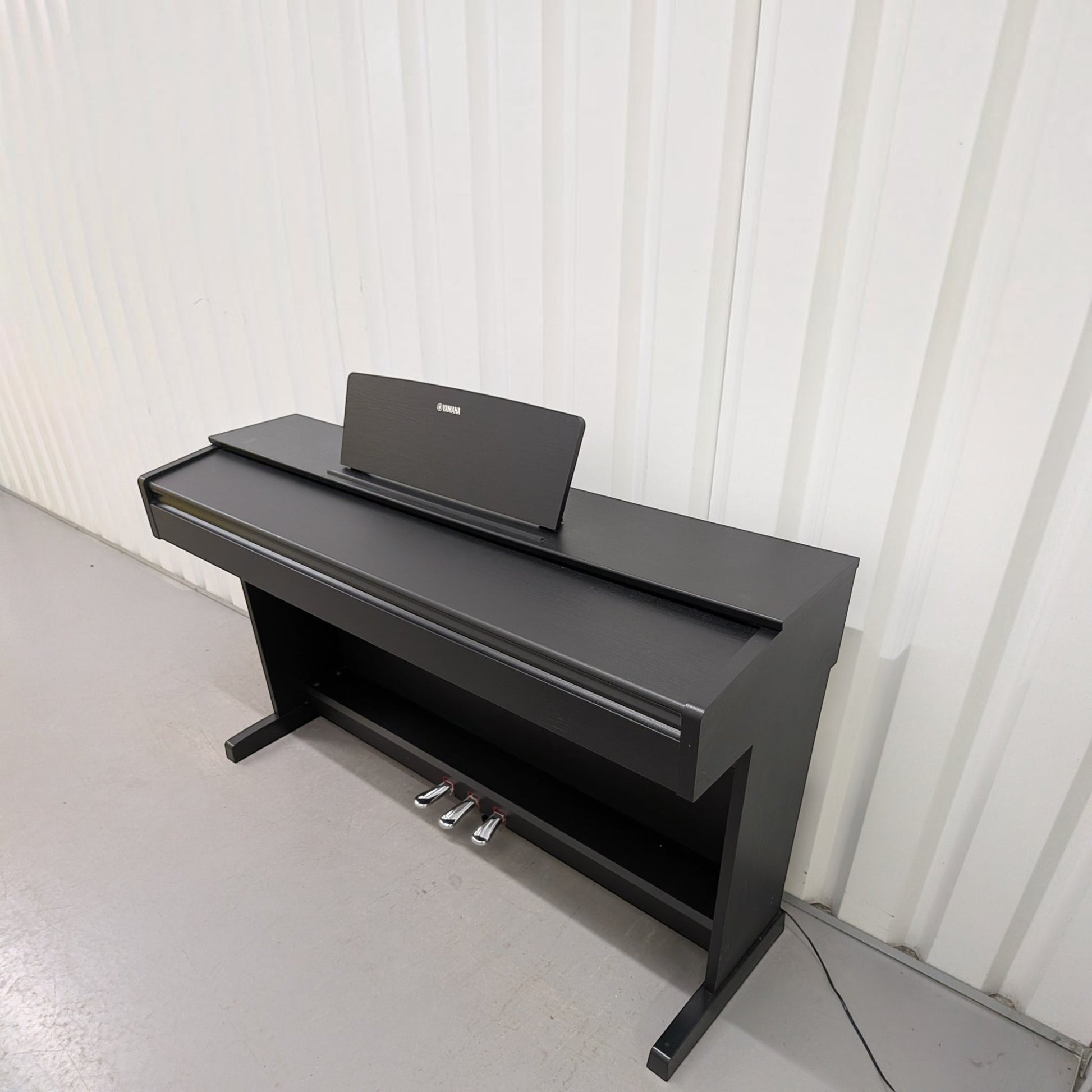 Đàn piano điện Yamaha YDP-103 màu đen dáng tủ trang nhã tại TÂN NHẠC CỤ, thiết kế gọn gàng với 3 pedal kim loại.