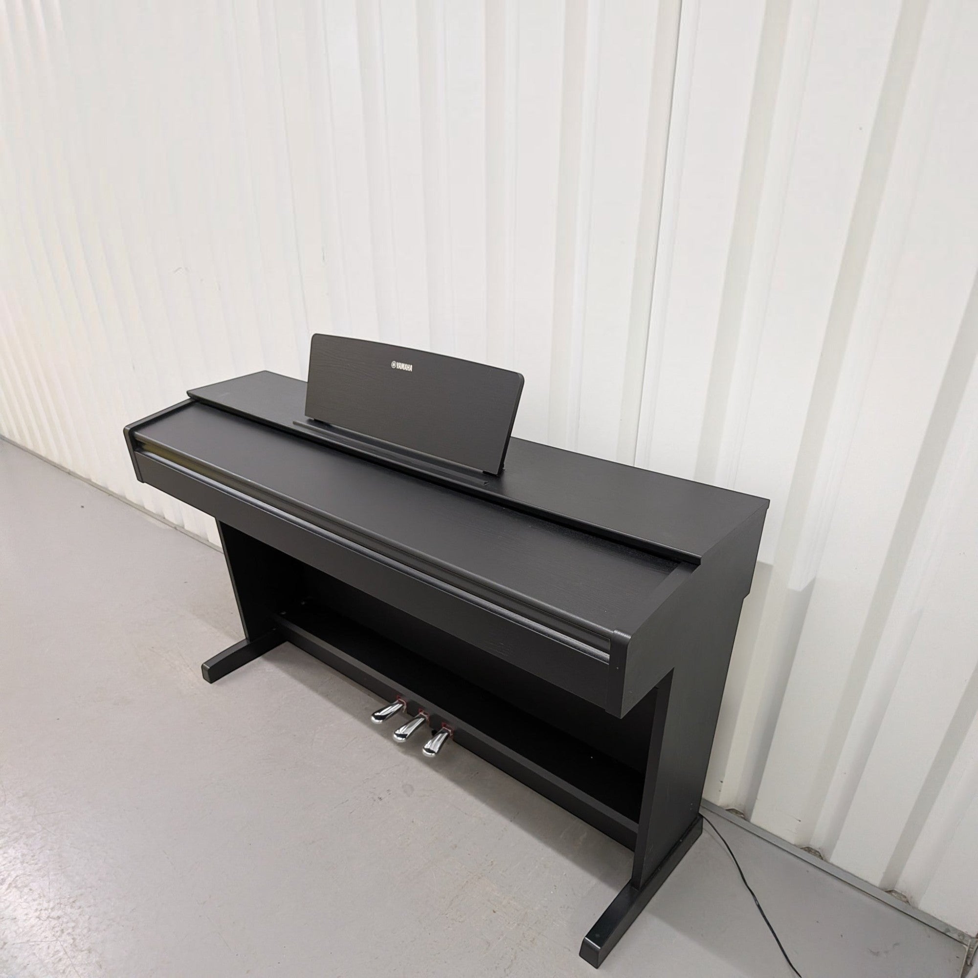 Đàn piano điện Yamaha YDP-103 màu đen dáng tủ trang nhã tại TÂN NHẠC CỤ, thiết kế gọn gàng với 3 pedal kim loại.