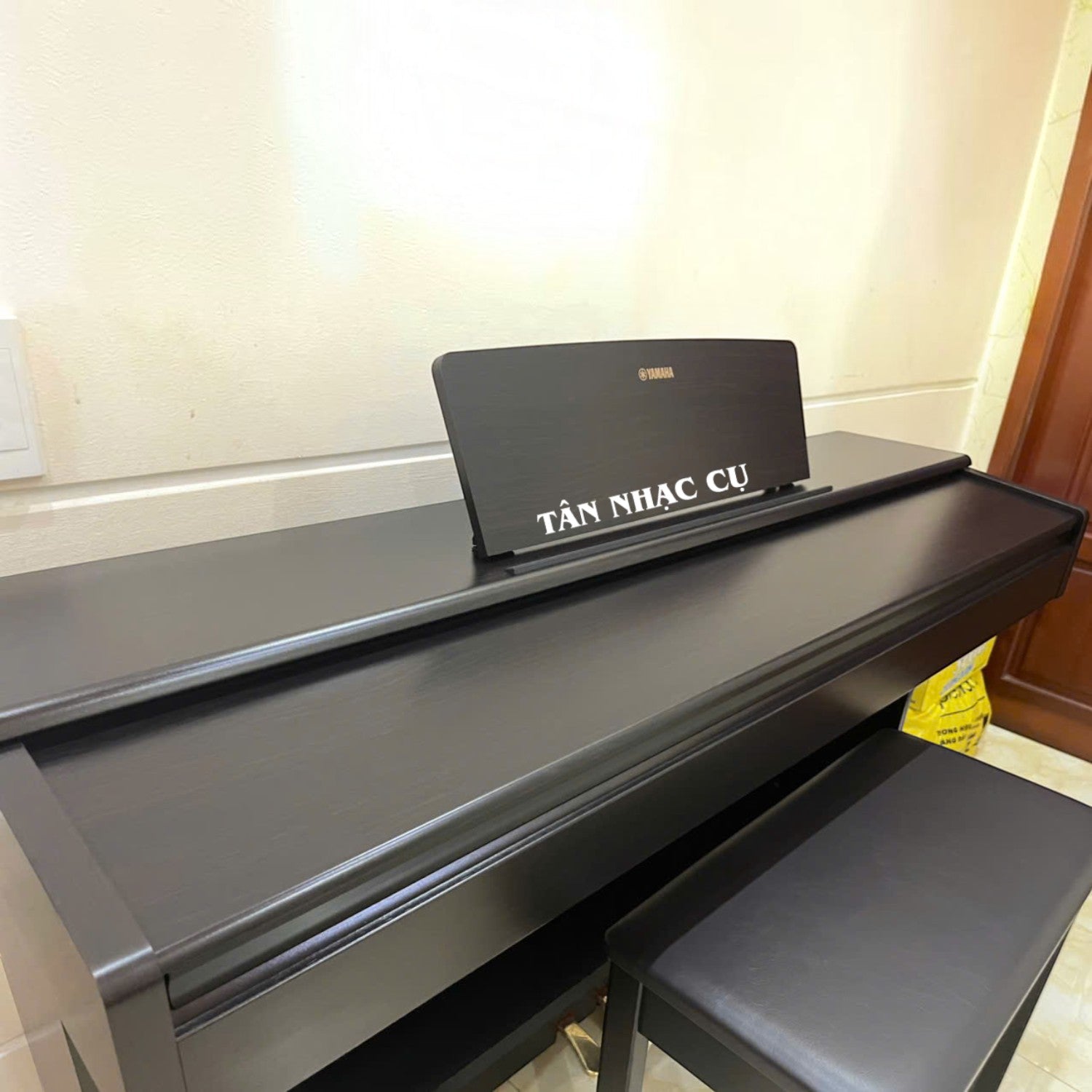 Đàn piano điện Yamaha YDP-105 màu đen sang trọng tại TÂN NHẠC CỤ, thiết kế dáng tủ đứng kèm ghế ngồi.