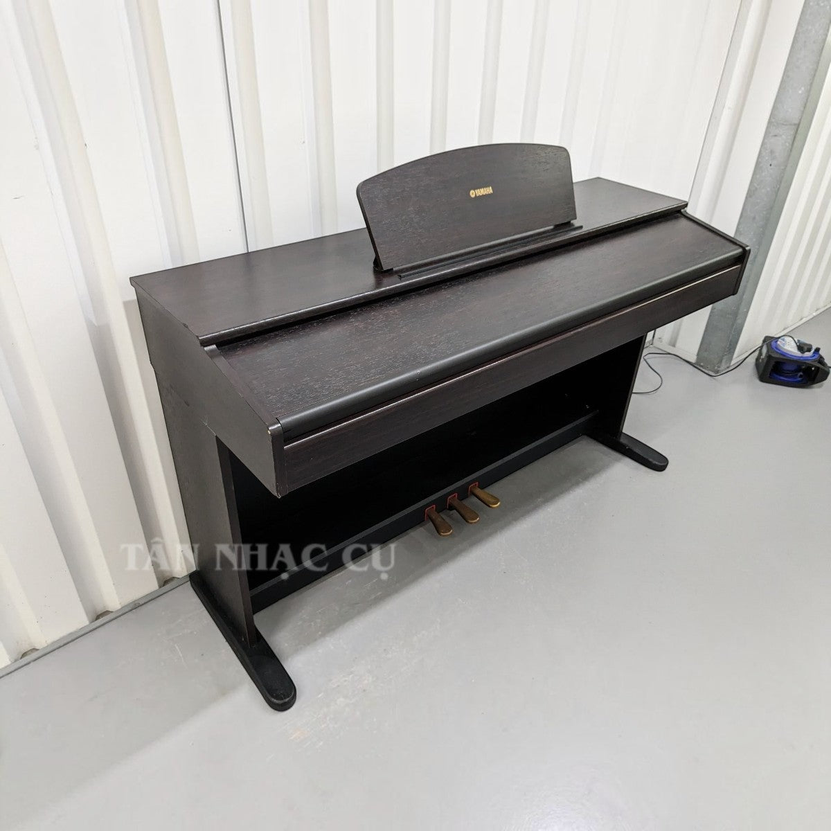 Đàn piano điện Yamaha YDP-121 màu nâu gỗ hồng tại cửa hàng TÂN NHẠC CỤ, thiết kế dáng tủ truyền thống với 3 bàn đạp.