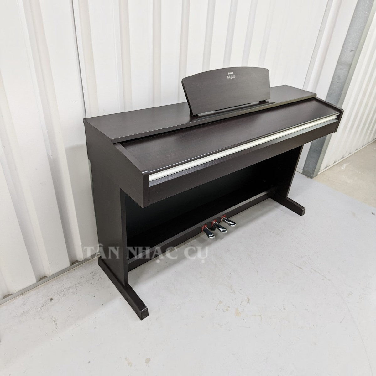 Đàn piano điện Yamaha YDP141 dáng tủ màu nâu đen sang trọng tại TÂN NHẠC CỤ với 3 pedal và nắp phím trượt