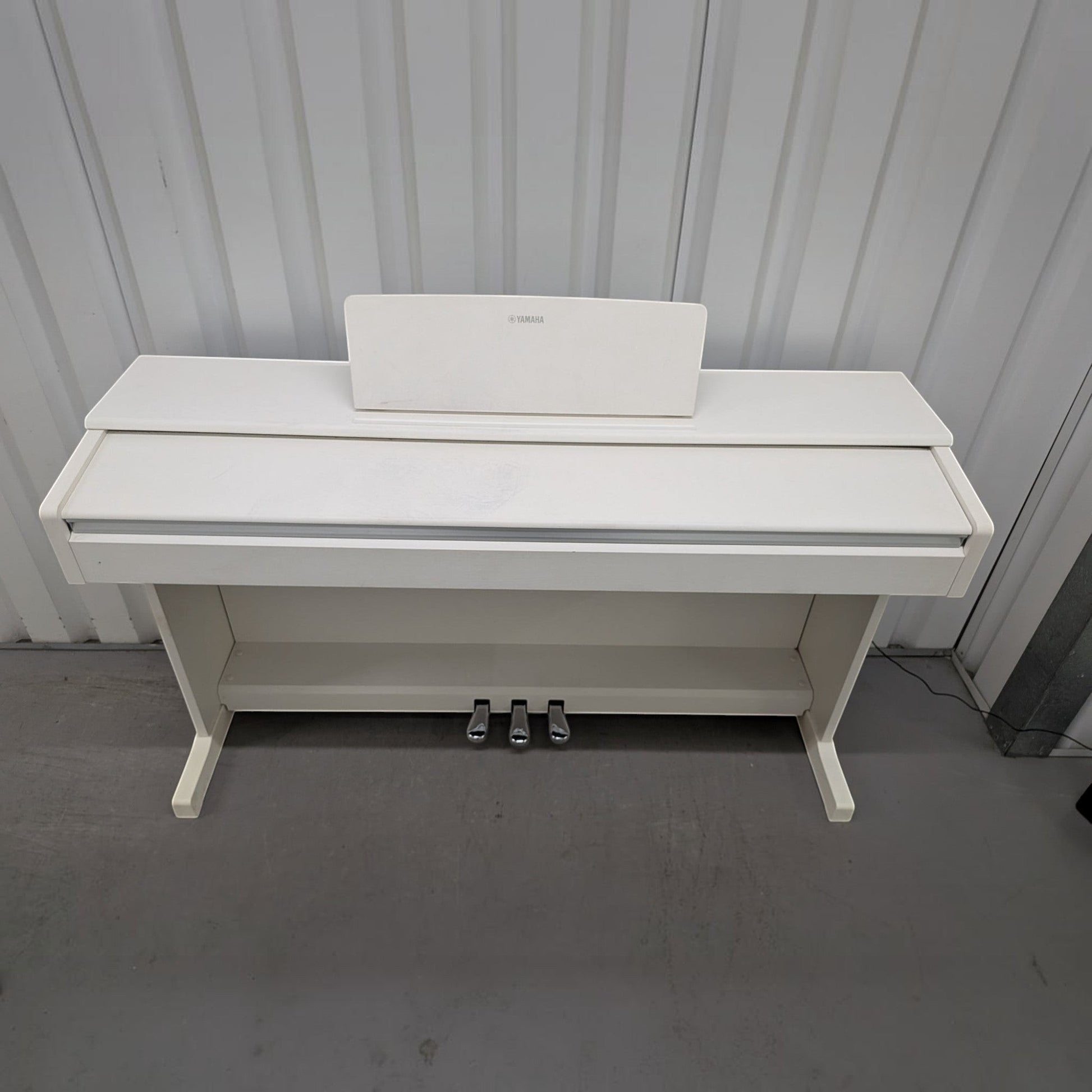 Đàn piano điện Yamaha YDP-144 màu trắng trang nhã tại TÂN NHẠC CỤ, thiết kế dáng tủ gọn gàng với 3 pedal kim loại.