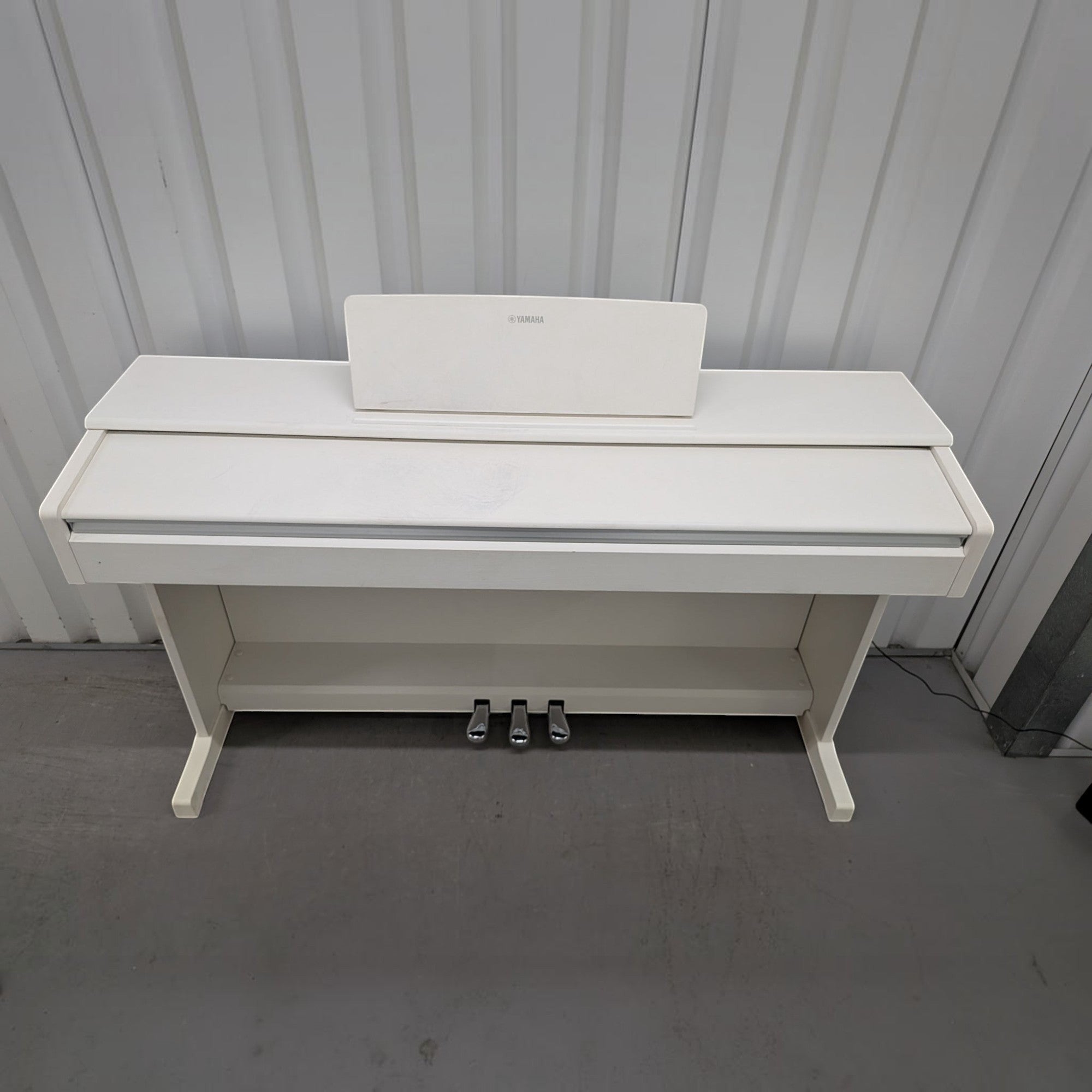 Đàn piano điện Yamaha YDP-144 màu trắng trang nhã tại TÂN NHẠC CỤ, thiết kế dáng tủ gọn gàng với 3 pedal kim loại.