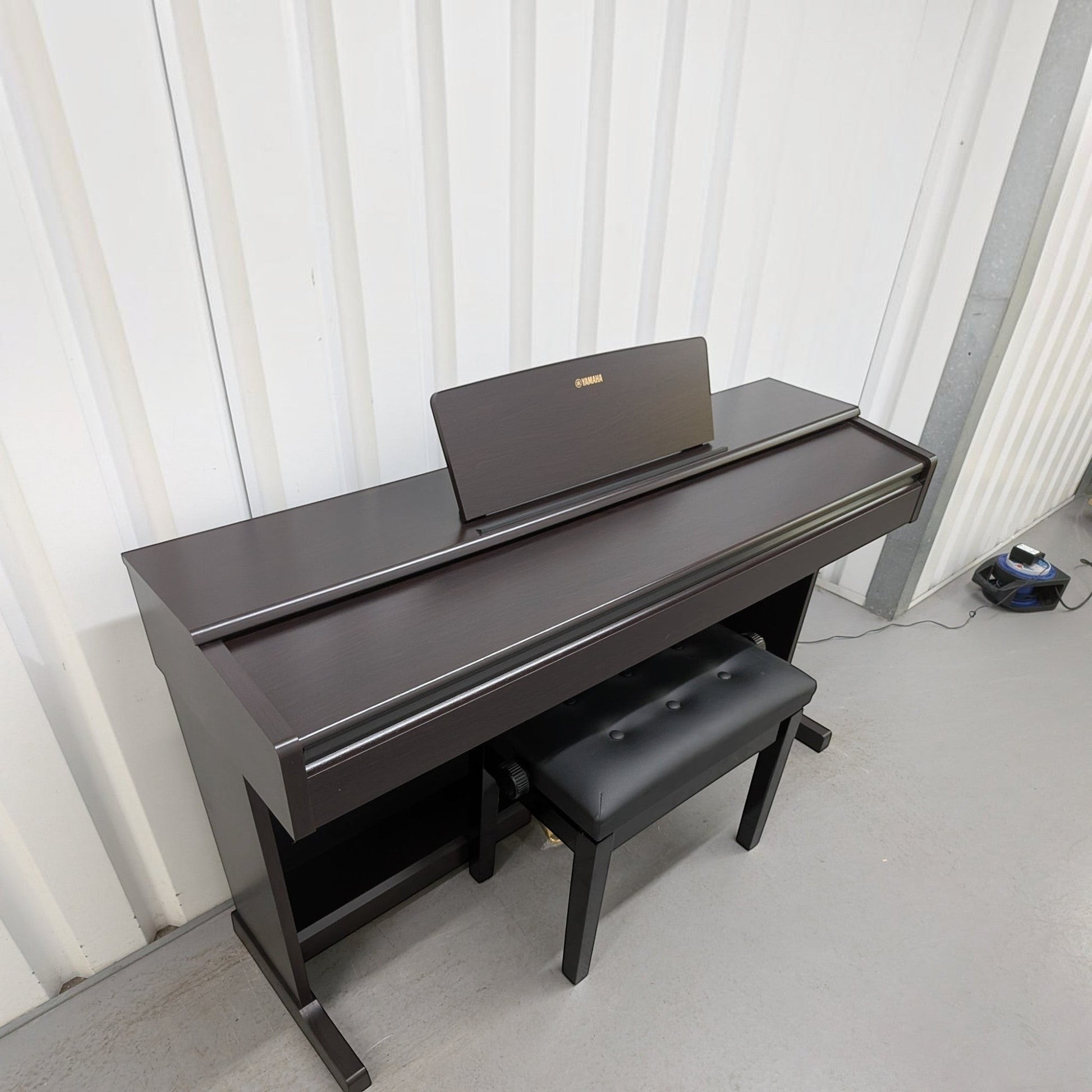 Đàn piano điện TÂN NHẠC CỤ Yamaha YDP-144 màu nâu gỗ sang trọng với ghế ngồi đi kèm, thiết kế dáng tủ hiện đại.