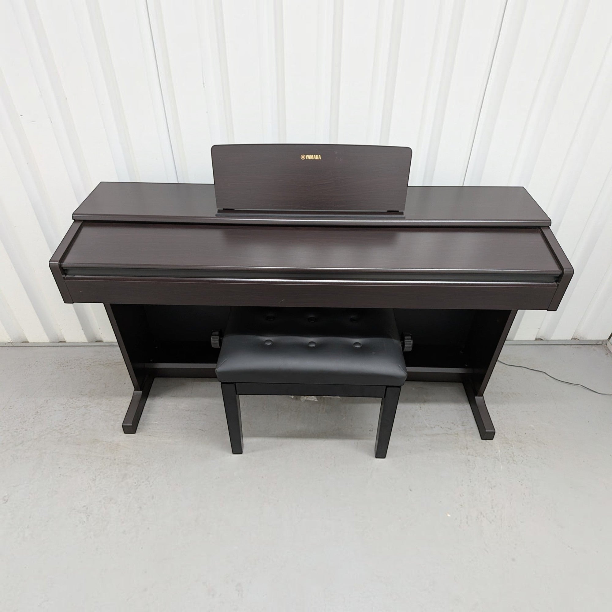 Đàn piano điện Yamaha YDP-144 màu nâu gỗ sang trọng tại TÂN NHẠC CỤ, thiết kế dáng tủ gọn gàng kèm ghế ngồi.