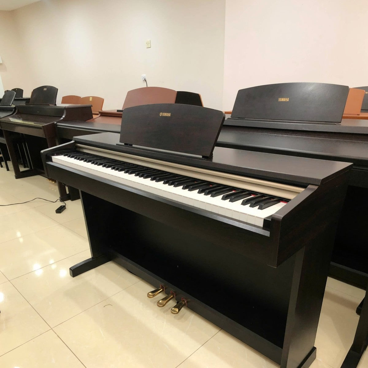 Đàn piano điện Yamaha YDP-151 màu gỗ nâu tại cửa hàng TÂN NHẠC CỤ, thiết kế dáng tủ sang trọng với 3 pedal.